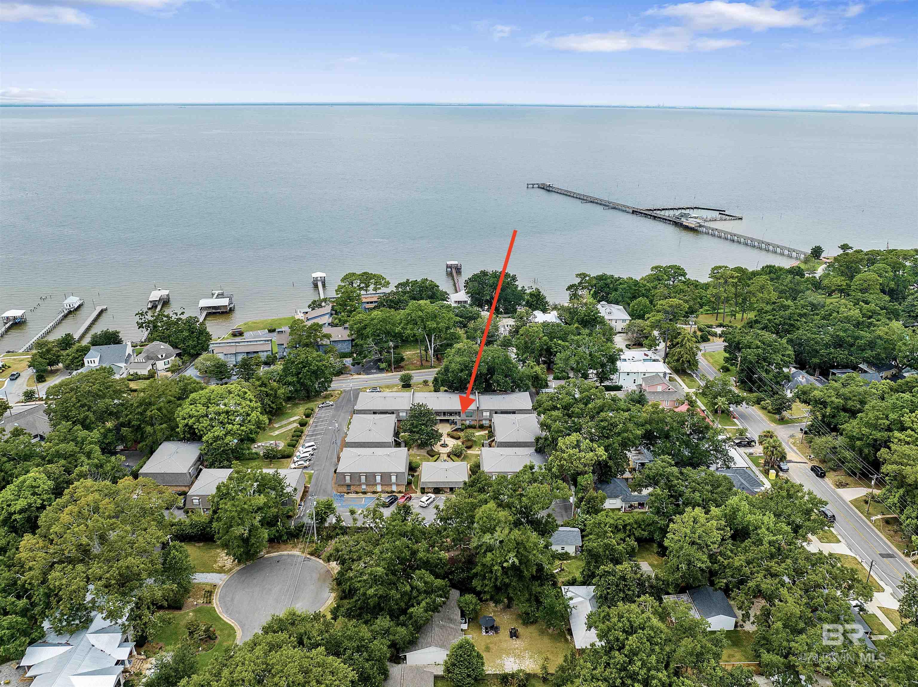 Welcome to Chateau Royale conveniently located in picturesque Fairhope and within walking distance of downtown Fairhope and its many shops and great dining opportunities. The Eastern Shore trail which spans over 20 miles along the Mobile Bay is literally steps away from this condo -  where you can enjoy great walking, biking and jogging...not to mention the breathtaking sunsets over Mobile Bay. The Fairhope Pier and public beach is also a short walk, great for paddle boarding or fishing. Situated in the complex away from any traffic noise, it's a quick walk to your reserved parking space and plenty of visitor parking. This condo has been freshly painted, offers tile throughout and is so clean and tidy, ready for a new owner! The living room offers plenty of space and dining room is nearby with new cabinetry offering convenient storage. The kitchen has brand new Whirlpool appliances with sleek tile countertops and plenty of cabinet space. The primary bedroom has 2 walk-in closets and offers ample space with nice light. The spacious bathroom is off the hall and has a separate vanity area with nice tile and counter tops. The A/C unit was recently replaced along with a smart thermostat so you'll be comfortable all year long, especially with the new double pane windows. This unit has its very own washer & dryer, which is rare in this complex. Enjoy listening to the courtyard fountain from the balcony seating area and use the community gas grill for your culinary needs, plus the clubhouse can be used for events and HOA gatherings. There are too many great things to list about this wonderful condo, call for your showing today!