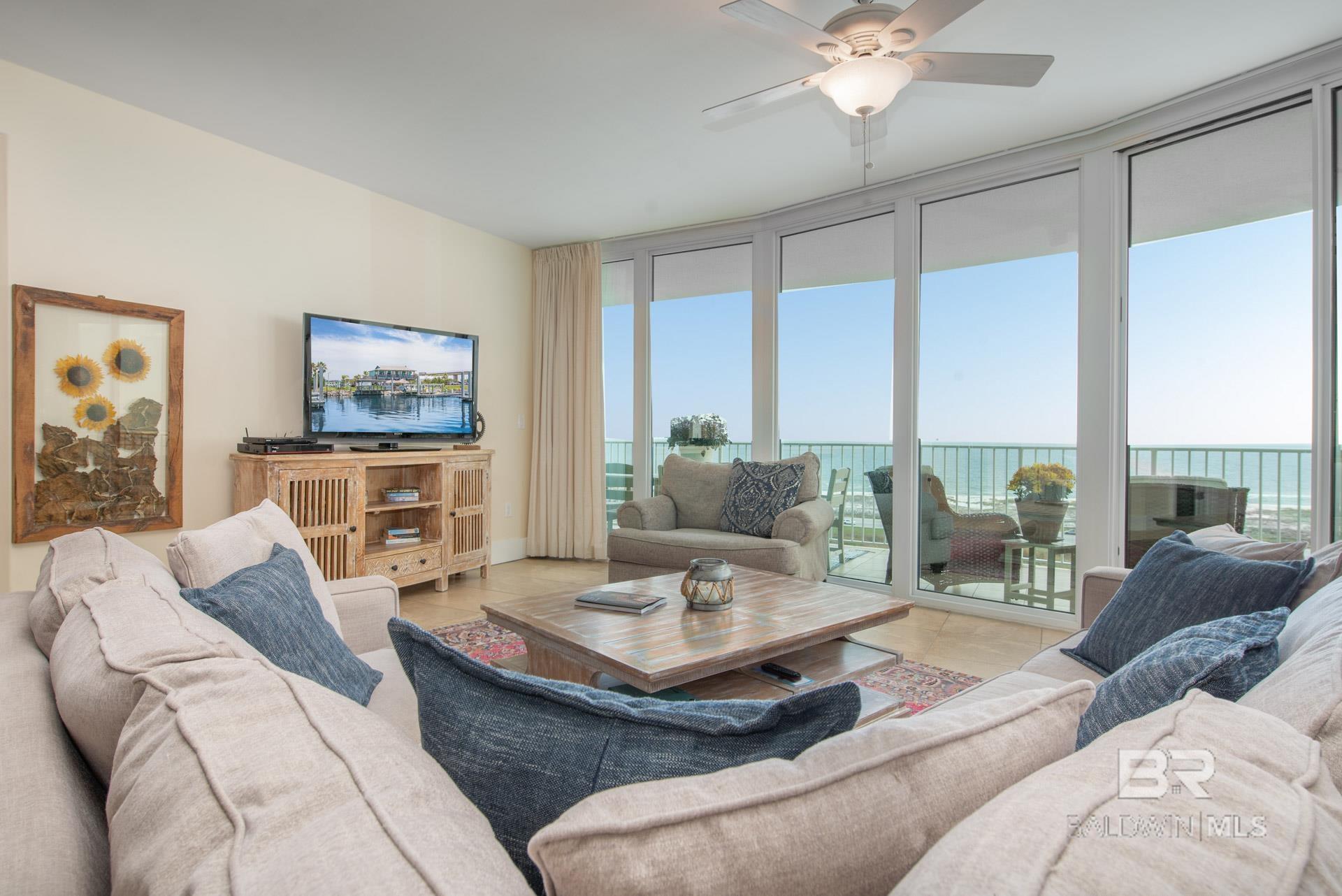 Living room featuring light tile patterned floors and ceiling fan