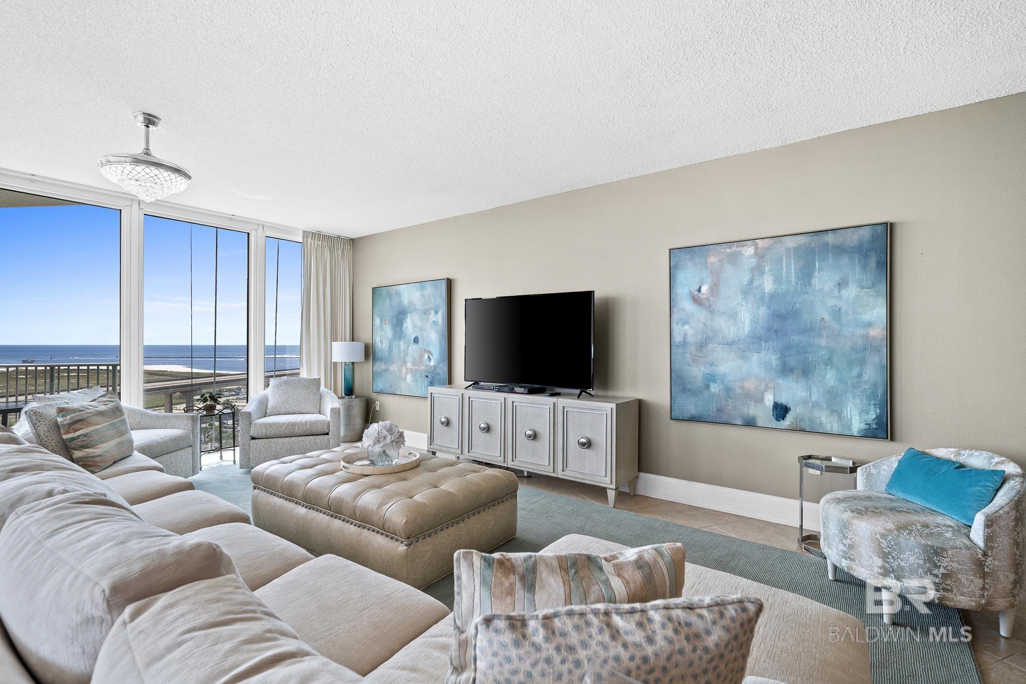 Living area with floor to ceiling windows, baseboards, and a textured ceiling