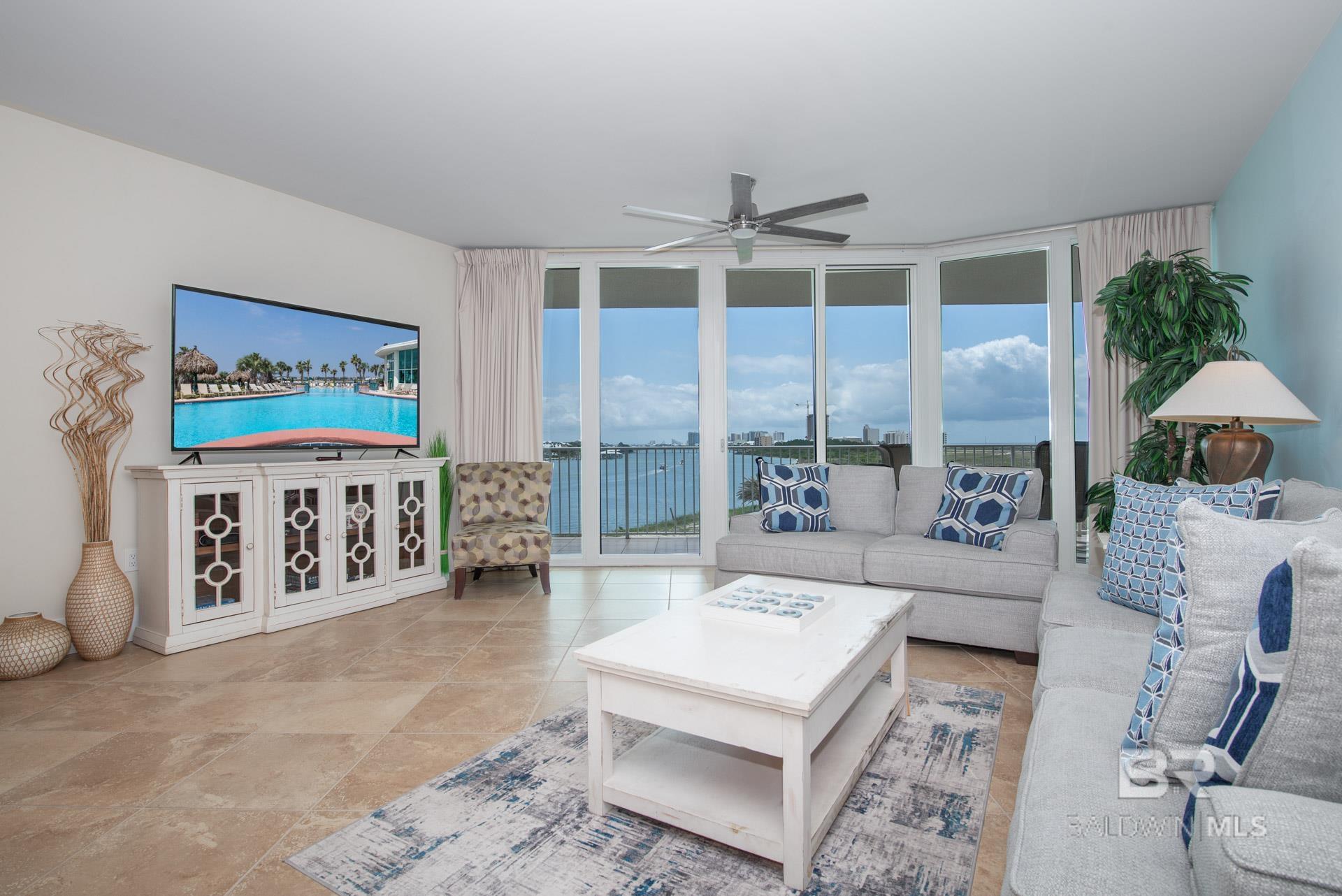 Living area with a wall of windows and a ceiling fan