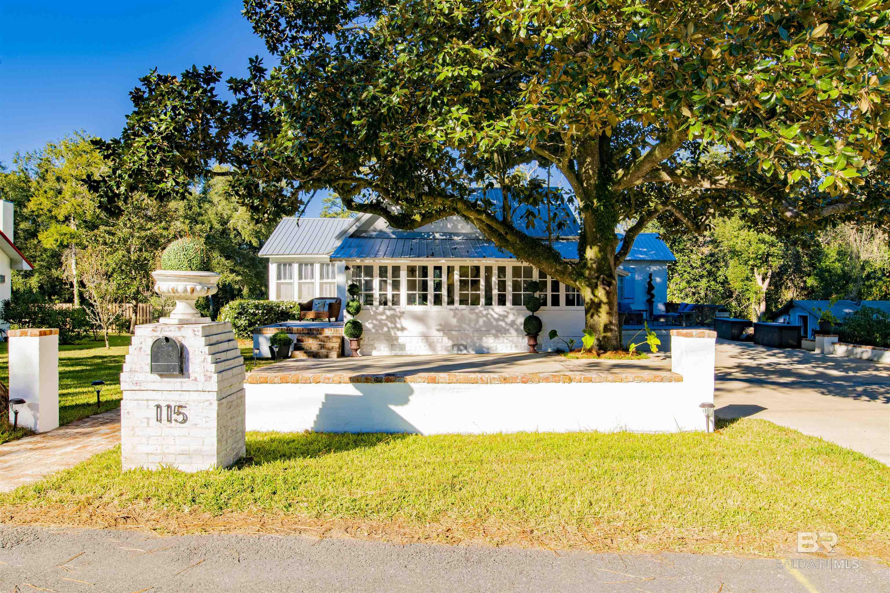 Welcome to 115 North Avenue, Fairhope. Come experience the lifestyle of living in Fairhope's MOST desirable Bluff Neighborhood. Less than 1,000 feet from MOBILE BAY!!! Enjoy peaceful walks from your front porch to the Fairhope Beach Park, Pier, and Mobile Bay or take a short walk into downtown Fairhope. This charming 1940's Bungalow features amazing views from the sunroom across the front of your home and is located on a 137' wide lot with ample storage, and an outside workshop. These wonderful cottages don't come along very often, especially as updated as this one and it's all about LOCATION, LOCATION, LOCATION! Open the door to this fabulous cottage and the first thing you notice is the original hardwood floors that sets the tone for a comfortable and inviting home. With 3 bedrooms and 3 baths with 1 bath done in 2020, you have plenty of room for the whole family and there's a great office space. Come sit in the roomy living area with fireplace that opens into your sunroom, completely enclosed with windows, not screened-in, and this space will definitely get a lot of use plus you have a side outdoor space off the sunroom. You must see this amazing kitchen which has new quartz countertops, new appliances, Travertine back splash, Travertine flooring in both kitchen and the dining area with a beautiful chandelier and high ceiling. Home renovations include new ceilings in both the kitchen and bedrooms, shower being added in one of the bathrooms, with NEW Tin Roof in 2019, new Rheem A/C in 2019, new Rheem water heater in 2017, some lighting and ceiling fans have been upgraded, freshly painted, and there is an amazing new deck to enjoy your wonderful outdoor space. The driveway will hold up to 6 cars, yard was newly sodded, brick mailbox was added, new back porch, Owner is currently replacing 2 windowpanes in living room, the average electric & gas is approx. $250/month including trash, water & sewer, and this home as current termite contact.