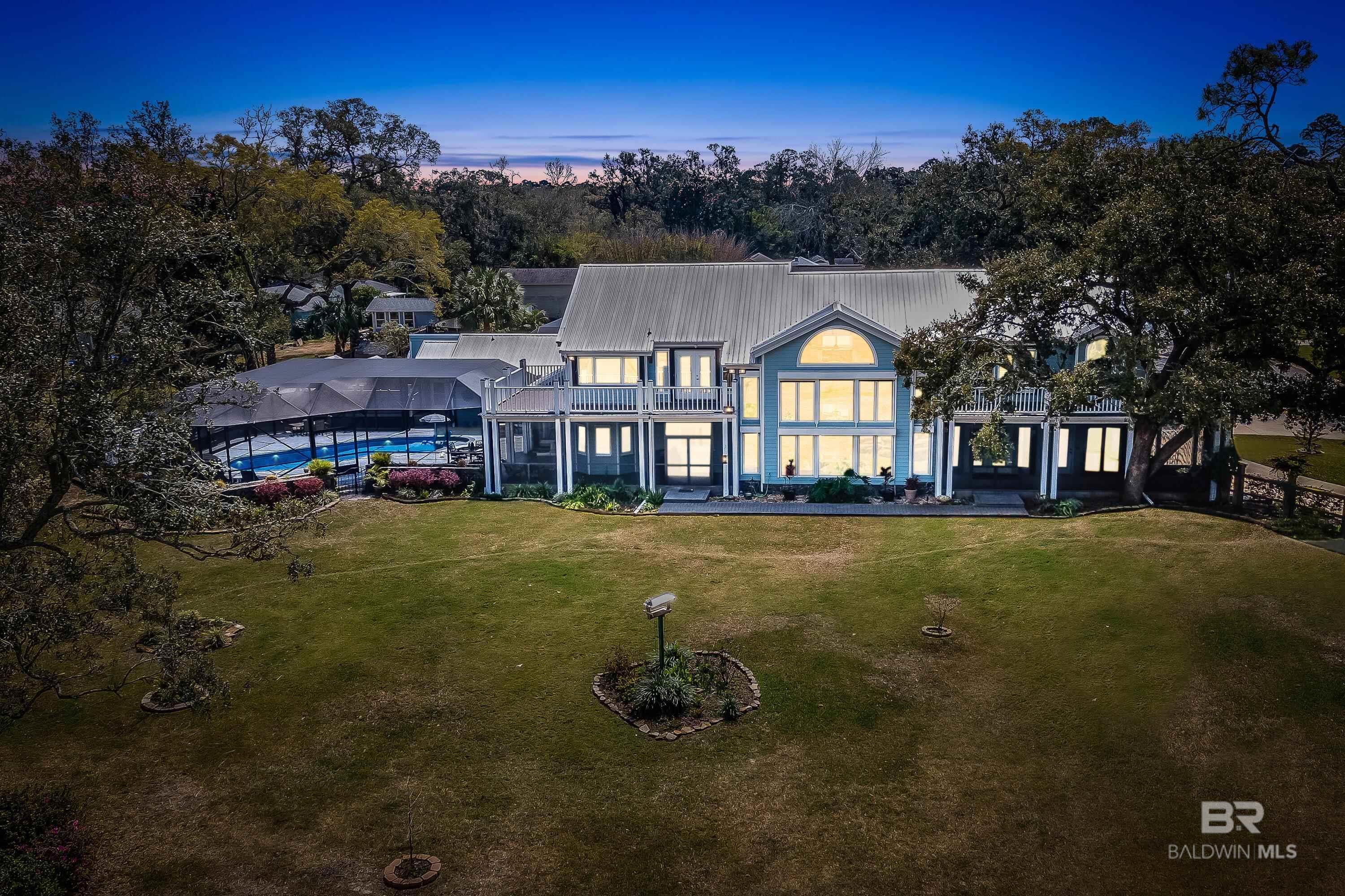 This awe inspiring Perdido Bay waterfront estate located on a high/dry lot dotted with magnificent heritage oaks and mature landscaping is minutes from downtown Pensacola, award winning Perdido Key Beaches, and Foley, AL. From its soaring ceilings, stone-faced fireplace, to multiple screened porches and fully screened lanai with a custom saltwater pool to the huge game room, this home is loaded with spaces and places for the ultimate coastal lifestyle! All manner of enjoyment avails itself here! Set on 1.35=/- acres with 145' of waterfront, there is a brand new boathouse with dual jet ski lifts,a 17K# boatlift, a sundeck and porch swing for leisurely days on the bay! Dolphin and pelican frolic and the sunsets are spectacular! The back lawn is fenced and large enough for volleyball badmitten and croquet, and there is a perfect outdoor bar area and firepit. The home welcomes you with a two-story entryway, leading to the grand family room w/cathedral ceilings,gas ventless fireplace and a stunning wall of windows overlooking the lawn and waterfront. Formally, or informally, cooking and dining will be a pleasure as the well equipped kitchen has double Thermador ovens, 6 burner gas cooktop, Sub Zero fridge, warming drawer, wine cooler and two dishwashers. Casual breakfast nook, pool side dining, or formal affair in the elegant dining room are all possibilities! Stage sumptuous meals in the Butler Pantry. 8 of 10 rooms has a waterview, and screened porch or waterfront balcony, each with either composite material or cool decking. A private balcony off of the master suite adds to the elegance of the spacious room. The master bath spa is luxuriously appointed with a large soaking tub, separate shower, granite vanities and an enormous wardrobe room. 2 upstairs bedrooms share a balcony and have private bathrooms. 1 ground level bedroom has a hall bath.NEW,NEW,NEW: HVAC & Duct, Metal roof,60K generator w/400 amp tx switch, elevator, exterior paint, LED flood lights, security.