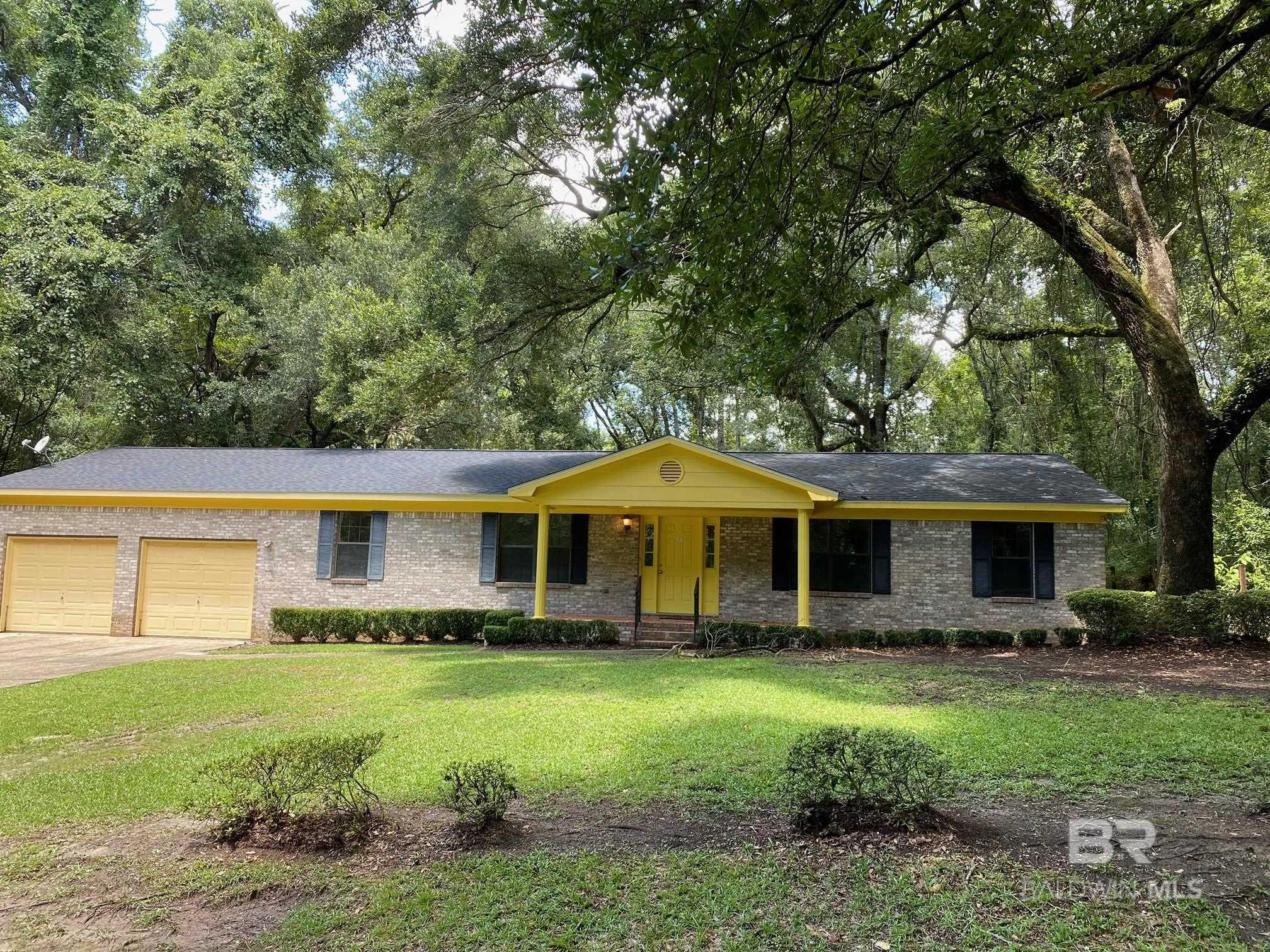Good Bones, Fixer Upper!! Huge lot!!! Great location!!! Bronze Fortified roof installed 2018. This is the opportunity for you to put your personal touches on a home. This home is surrounded by sprawling gorgeous mature Live Oaks, it's a 2 block walk to the bay to see sunsets, and sits on a large 300 x 100 lot, potentially large enough to build an additional home. The house needs flooring, appliances, and updates to the bathrooms and kitchen. Woods Ave. is a small street tucked away behind the football and baseball fields of Fairhope. It only has 4 houses on it, and the home is across the street from walking trails that lead to the dog park.