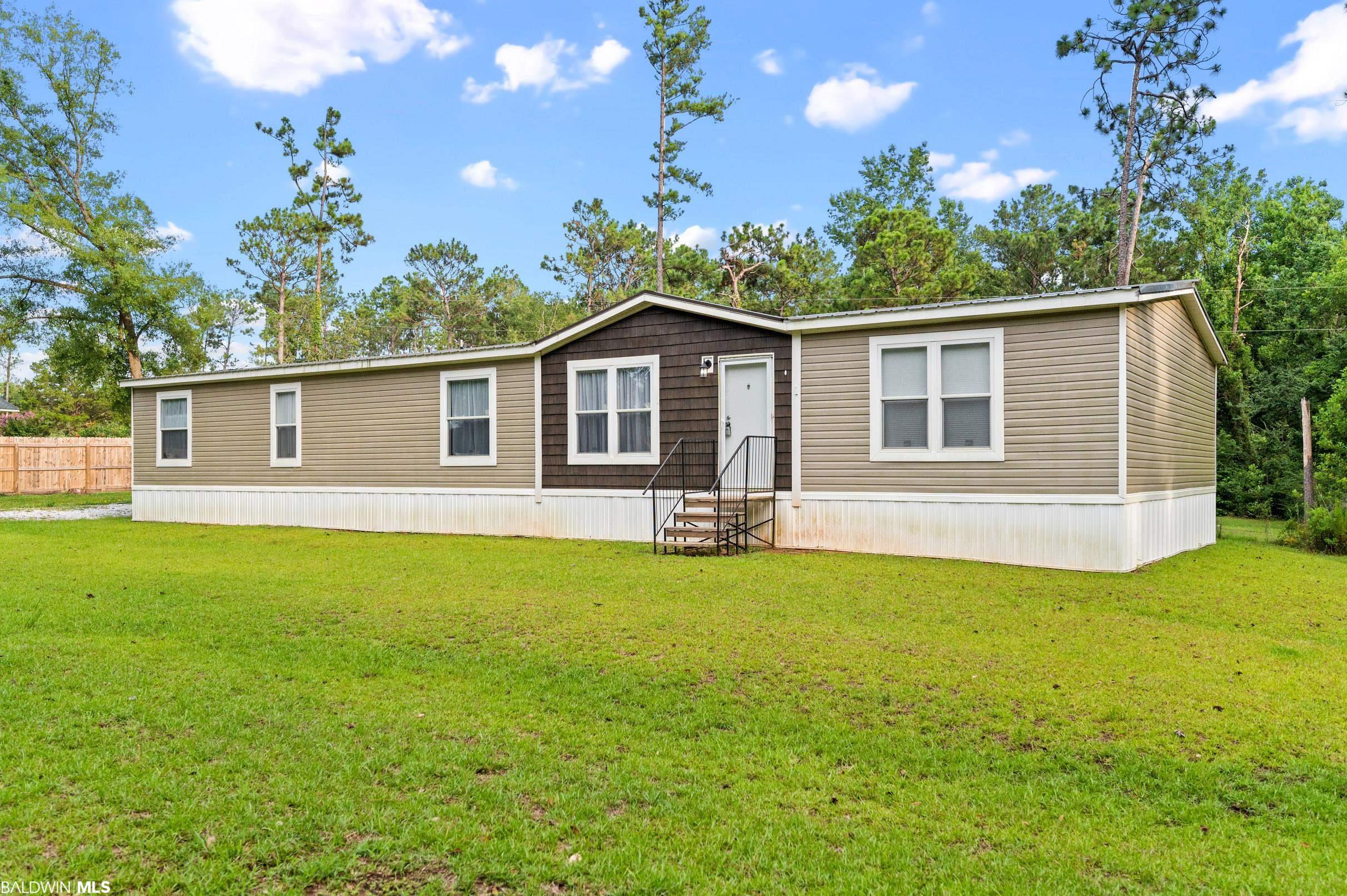 Lowest price move in ready home in Fairhope on an incredible lot in Fairhope, Alabama! On over an Acre with a state-of-the-art 2022 Hamilton VERMONT MODEL mobile home.  The home has 4BRs and 3baths and has barely been lived in.  It is on 1.3 acres in East Fairhope.  Fairhope schools with country living.   All rooms are spaciously sized.  Great floorplan with living room and separate den.  Large cook's kitchen with windows overlooking the beautiful lot.  Kitchen has lots of Cabinetry and storage.  Sep. Dining Area and Split bedroom plan.  Outdoor Storage/Workshop building has AC, plumbing and a commode conveys.  Unzoned, Deeded land on a private lane.  This is a can't miss.  Seller has relocated. Ask listing agent for detailed lender list for great programs on this home.