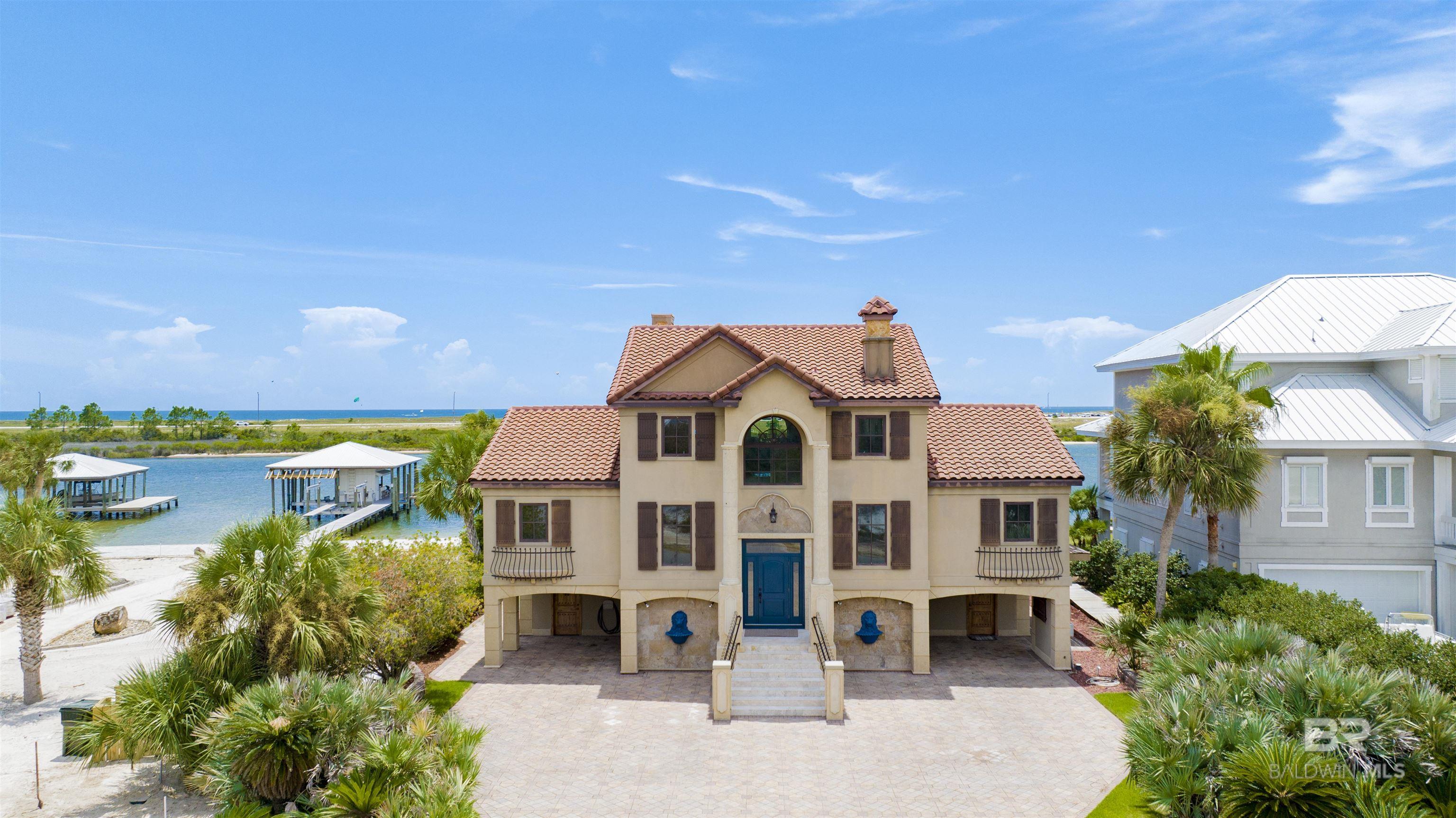 This BEAUTIFUL unique Mediterranean Ono Island home is a boater’s paradise!  It's perfectly situated on over 100 feet of pristine water frontage. Offers unobstructed and breathtaking views of Ole River and the Gulf of Mexico. The home is conveniently located at the west end of the Island! Home is very close to the Ono bridge and to Perdido Pass. For those with large boats, the home offers no-wake deep water access and a 75'+/- slip capable of 70 feet in length. Situated on the west side of Ono Island bridge. Any size sport fishing towers will have no issue traveling to and from the Gulf.  Lots of space to entertain and relax with family and friends! This beautiful castle style home has lots of potential to make it your own style. It has seventeen-foot ceilings in the living room,  large crown molding, beautiful Iron work, an elevator, impact glass windows, a brick-paved driveway, two spacious covered outdoor areas, a white-sand beach, new seawall, and ThruFlow decking on the pier. The house has two water front master suites with the primary master suite offering a fireplace, wet bar, double vanity, his and her walk-in closets, a tiled walk-in shower, and a jetted tub. The home also has two spacious entertainment areas providing a combination of wet bars, bar seating, built-in wine racks, an lots of cabinet space, refrigerators, an ice-maker, and expansive water views. The home’s kitchen has granite countertops, a tiled backsplash, stainless steel appliances, a built-in refrigerator, two built-in ovens, a microwave drawer, under-cabinet lighting. This home is a MUST SEE!!