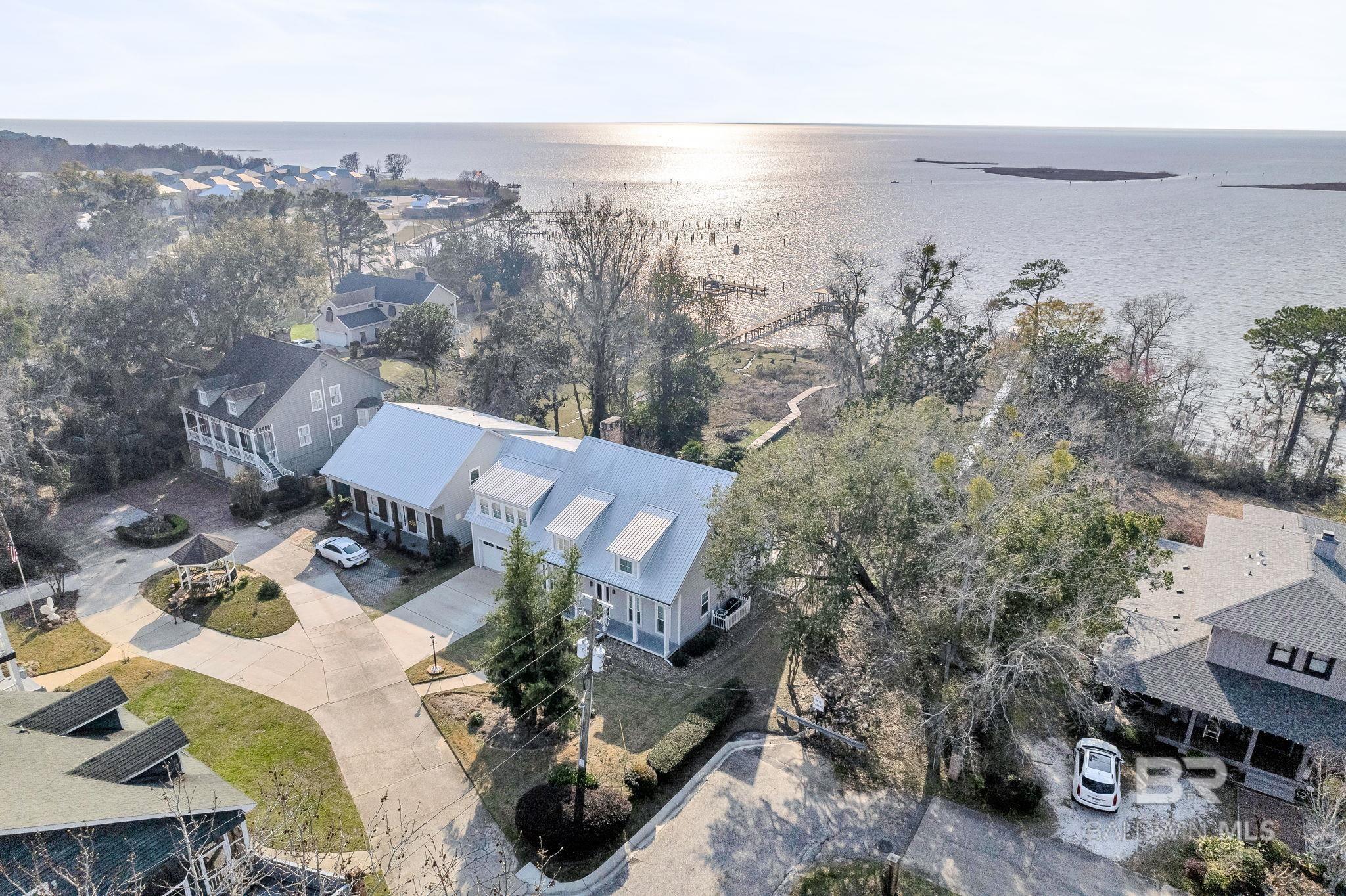 Welcome to waterfront serenity in Daphne, AL! This 3284 sq ft immaculately updated 4-bedroom, 3.5-bathroom home offers unparalleled views of Mobile Bay's Eastern Shore sunsets from your private pier and back porch. Nestled on a high-elevation .53 acre lot with 65' of waterfront, the home features a modern kitchen with soft close cabinets, granite countertops, and beautifully upgraded bathrooms. Recent upgrades, including a new HVAC system (2024), Pella windows, and fresh interior paint, enhance its allure. Additional highlights include a separate office/den, hardwood floors, spacious closets, plantation shutters, sprinkler system . With easy access to shopping, Downtown Daphne, Mobile, and Bay Front Park, residents also enjoy privileges at the Lake Forest Golf Course, pools, clubhouse, and tennis courts. Your dream coastal lifestyle awaits!