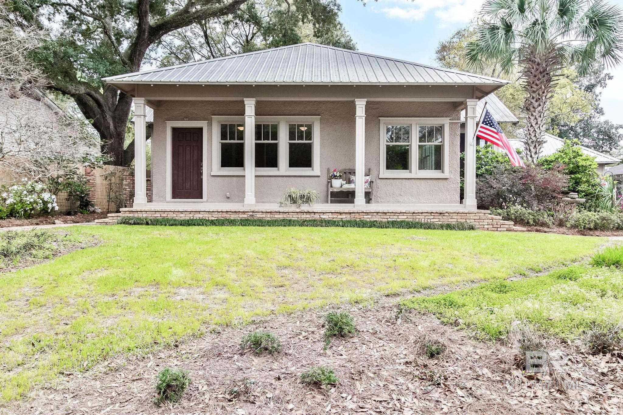 This Historic Fairhope Cottage is located just a short walking distance to Downtown Fairhope, two neighborhood parks and the Beautiful Bay Front parks that are enticing people flock to this area! This home has 3 sizable bedrooms and 2 updated bathrooms with just under 1500 square feet of living space. There is also a 1 car garage/separate carriage house that was built in 2011 with a 14 x 15 workshop, that could be converted into a separate studio apartment, and a 12x 8 tool closet that combined has close to 670 square feet usable space. The finishes are very inviting with Beautiful Pine floors throughout, tall ceilings in every room, custom built in shelving, wood accented walls, craftsman trim, a metal roof installed in 2005, and also all of the windows have been updated with Anderson 3 over 1 windows! Just off the kitchen you will love the enclosed Florida room with antique tongue and groove walls that opens into a 11 x 10 screened in porch. This property is exactly what you picture when you want to live in a downtown cottage, it has all of the character you have dreamed about when moving to Downtown Fairhope!