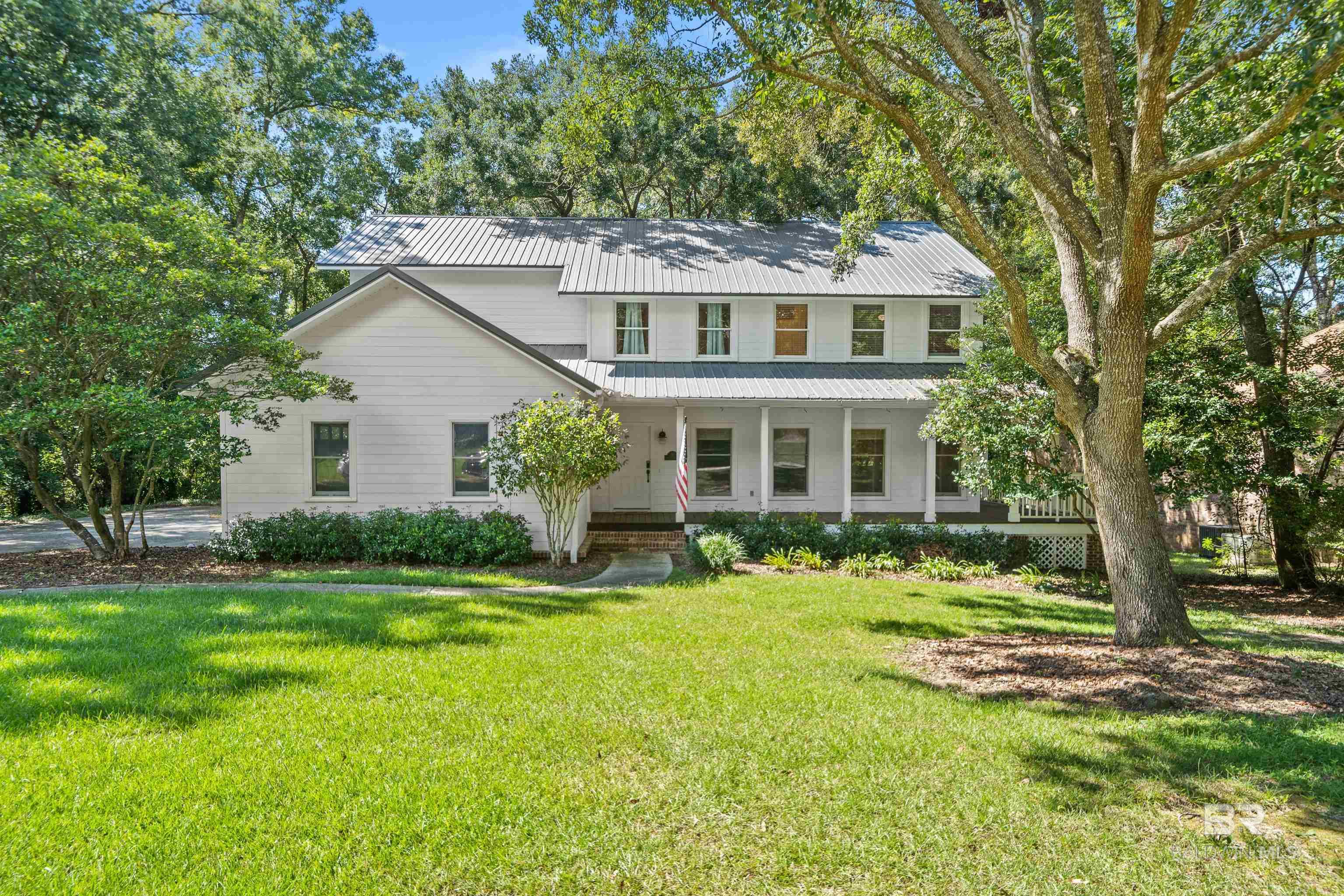 Southern Living at its finest.  This stately home in Fairhope, Al is located just minutes from Downtown Fairhope and Mobile Bay.  Move right into this 5 Bedroom 3 and a half bath well built and maintained home.  Spend your afternoons and mornings on the expansive porches enjoying the beautiful fenced in yard and privacy the lot provides.  It's at the back of the cul-de-sac surrounded by custom homes. The layout has a separate living room and den with a kitchen and morning room and primary bedroom located downstairs and the additional bedrooms and bathrooms upstairs. Inside there are hardwood floors, a recently updated kitchen that includes beautiful stainless appliances, granite countertops, a large kitchen pantry and eat in kitchen with a built-in bar.  The primary bedroom is spacious, has a big walk-in closet and is located on the main floor for privacy.  The attached primary bathroom includes a custom shower, new countertops and newer cabinets.  Upstairs are the additional 4 bedrooms that include walk in closets and loads of storage.  The numerous windows allow for the natural light to pour into the home at all times of the day which accents the quality of construction and the soaring ceilings. Some of the notable updates are HVAC's that are only a few years old, a metal roof and outdoor storage.  If you're looking for room, privacy, location in Fairhope close to downtown, all of the restaurants, boutique shops, and features in town this is the house.  This beautiful home is ready and easy to tour anytime. Buyer to verify all information during due diligence.