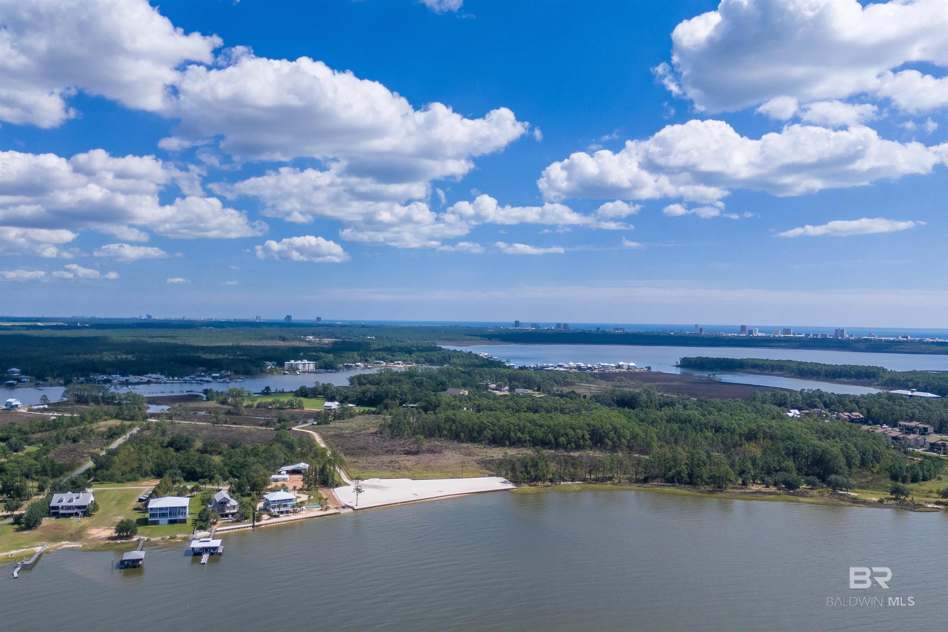 Approved for 11 Residential units and 12 Boat Slips. 425 FEET OF DIRECT WATERFRONT! VERY RARE WATERFRONT DEVELOPMENT OPPORTUNITY! WATER, SEWER AND POWER and Security Lights INSTALLED TO END OF DRIVE!   940 ft 6" water main , 940 ft 2" Sewer Force Main and Overhead Power 940 ft AND rock for base on road to get ready for asphalt.. APPROVED PLANS FOR 11 LAND CONDO SINGLE FAMILY DWELLINGS, COMMUNITY POOL PLUS LARGE PIER with FISH CLEANING STATION AND 12 BOAT SLIPS! This waterfront development BOAST 425 foot of bulkhead with continuous DIRECT FRONT water views of MOBILE BAY AND BONSECOUR BAY! MINUTES BOAT RIDE TO THE GULF OF MEXICO!  BULKHEAD HAS BEEN INSTALLED ON EDGE OF WETLANDS. BEAUTIFUL WHITE SANDY UPLANDS READY TO BUILD ON!  Lot sizes range from 28x60 to 30x60, Unit sizes range from 1500 sq ft to 1920 sq ft. per story, go three stories if you want! A COMMUNITY POOL also approved, very few CONDITIONS! APPROVAL FOR LARGE PIER AND 12 BOAT SLIPS. COUNTY ZONING HAS NOT BEEN INSTITUTED SO YOU COULD BUILD A CONDO OR OTHER DEVELOPMENT!  WATERFRONT PROPERTY IS SCARCE! The location is conveniently positioned in the HEART OF GULF SHORES!  MINUTES TO SEVERAL INFAMOUS ATTRACTIONS AND RESTAURANTS! GULF SHORES AREA IS VERY POPULAR TO DEVELOPERS,  INVESTORS, TOURIST AND HOME OWNERS!  THIS IS A RARE OPPORTUNITY! THIS DEVELOPMENT SITE IS A HOME RUN! PRICE .  APPROVAL FOR UTILITES, ETC HAVE BEEN APPROVED.   ROADS FOR/TO LOTS HAVE NOT BEEN BUILT.  PROPERTY IS BEING SOLD AS IS! Buyer to verify all information during due diligence.