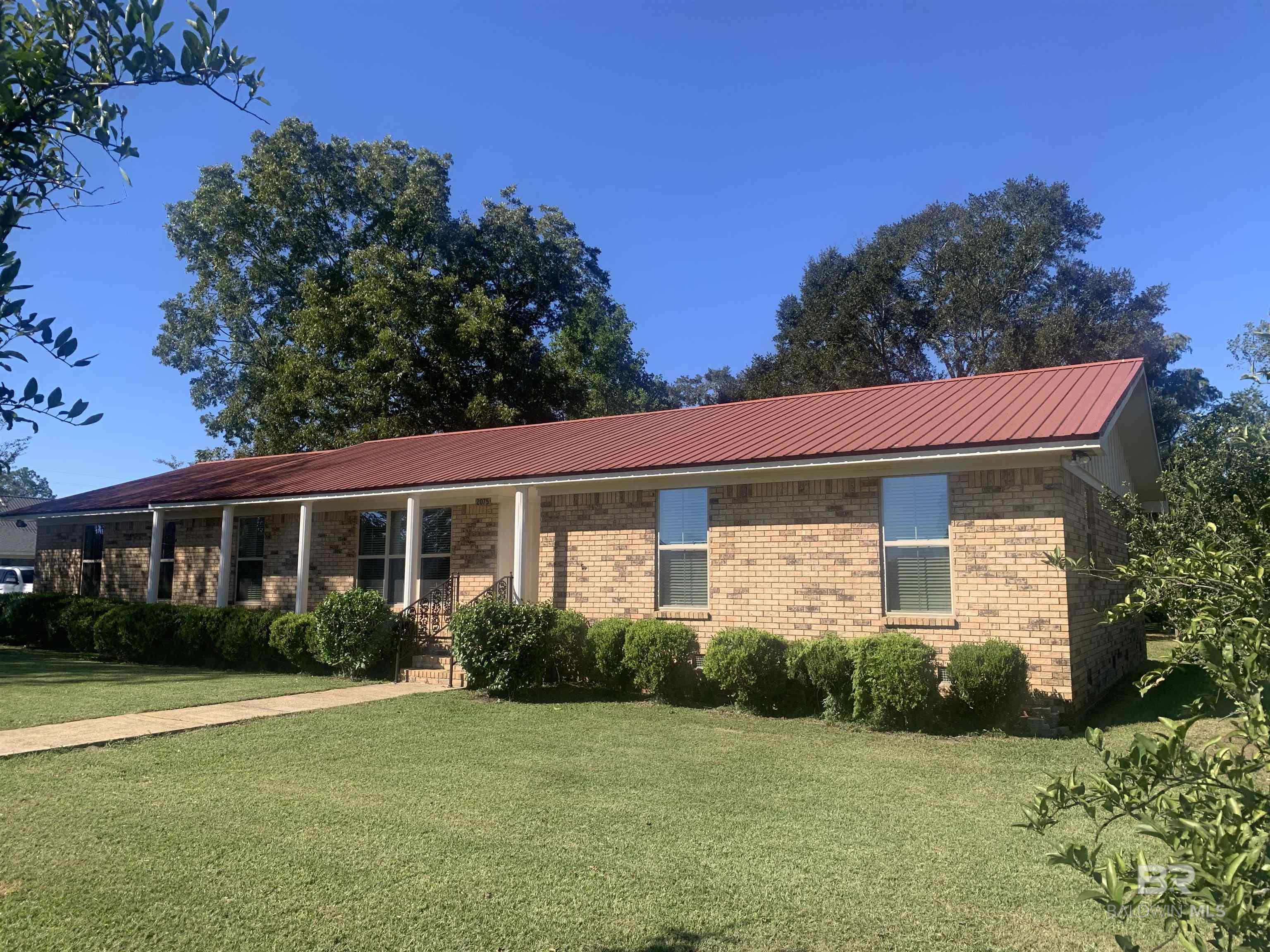 Great location facing Union Ave/CO RD 64 and one block off State Hwy 59. In the heart of Loxley! This home is conveniently located to I-10 & the Baldwin Beach Express.  The well built ranch style home has a low maintenance brick exterior and metal roof. The back features a large deck for entertaining, star gazing, and sunset watching. Original hardwoods & tile floors throughout, along with wood paneling in several rooms. Several rooms could be multi-purpose. One bedroom is set up with built in shelving, perfect for an office. The small den could be a separate dining room, leaving the formal living room/dining area to be a massive great room! Endless possibilities! Numerous mature shrubs, fruit, and nut trees make up the landscaping. Loxley Elementary is being built just down the street & the new Baldwin Preparatory School is located just up Hwy 59. The property has tremendous potential due to it's location & sound structure! The home is move in ready with all new double pane, Low-E windows, Blinds, & interior paint. Just begging for your finishing touches. Could possibly be re-zoned to commercial. Please call The City of Loxley planning and zoning for information on zoning. Buyer to verify all information during due diligence.