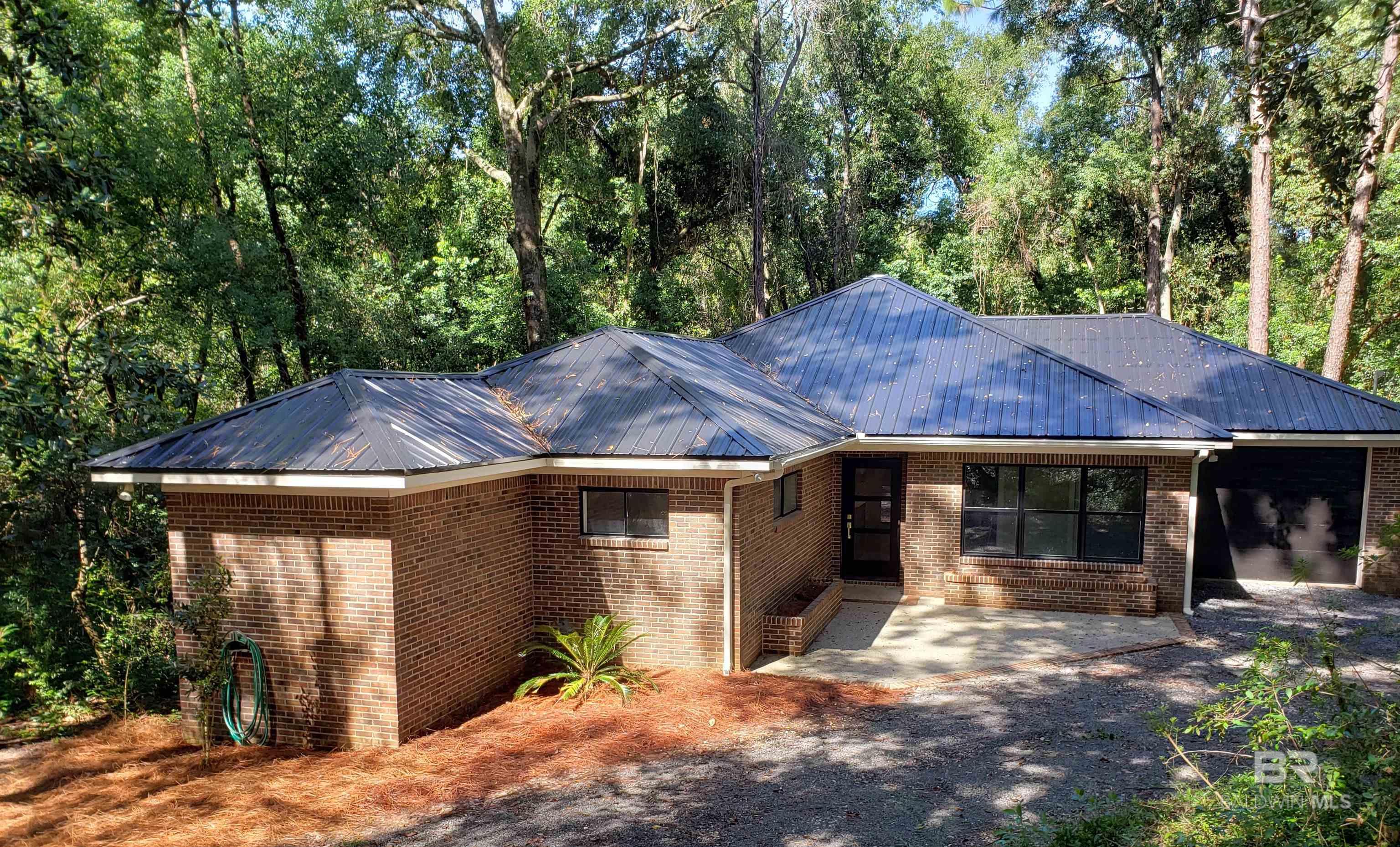 Brand new renovation just completed! Unbelievably serene and private home surrounded by nature's beauty within walking distance to downtown Fairhope. A must see! Recent additions include: New metal roof, HVAC, plumbing, electrical, gas fixtures, appliances, LVP flooring, kitchen cabinets, bathroom vanities, new fixtures throughout lighting, floor to ceiling porcelain walls in primary bath. 9 foot ceilings throughout the home. Private porch off the primary bedroom and an additional huge wraparound back porch overlooking the woodlands. Buyer to verify all information during due diligence.