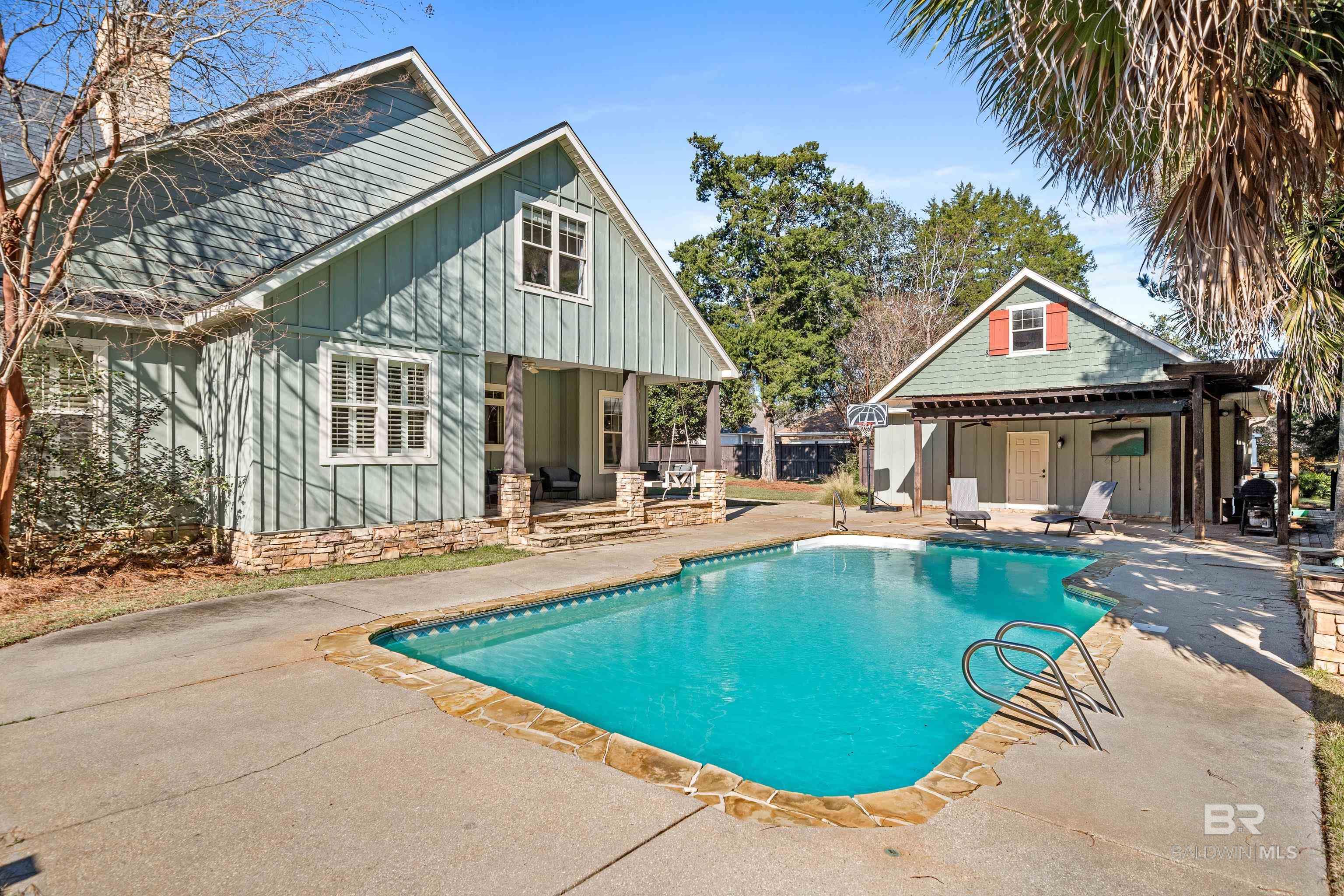 WOW!  PRICE IMPROVEMENT!  AND LOCATION, LOCATION POOLCATION!  Your sun-soaked Southern dream home for sale in Historic Malbis is waiting with a private oasis at the end of Tampary Street.  This 3 bedroom, 2.5 bath charming, craftsman-style cottage features fresh paint, brand new carpet, and a vibe that screams sip-something-sparkly-on-the-porch-swing while the kids cannonball into the saltwater pool. Talk about resort-style living—without the resort fees!!  2023 FORTIFIED ROOF means you’re covered (literally).  Got friends coming over?  Fire up your grill under the pergola and let the good times roll.  Cozy up with a great book on the porch swing and enjoy the sounds of nature all around.  Inside, the double-sided gas fireplace keeps the vibes cozy from both the living room and the kitchen/dining combo. The oversized primary suite upstairs is your grown-up getaway, while the 2 downstairs bedrooms are perfect for kiddos or guests.  BONUS ROUND: The garage apartment is a total game changer — whether you need a guest suite, home office or art studio.  And there’s a pool bath in the garage for quick access when enjoying the outdoor festivities.  How convenient! In this golf cart-friendly neighborhood, you’re just a cruise away from lattes, local eats, cocktail spots, and shopping galore. Beach day? You’re minutes from the white sands of the Gulf Coast and a quick commute to Mobile or Pensacola. This isn’t just a house—it’s a whole mood with wood floors, stone accents, soaring ceilings.  Don’t miss your chance to live in one of the most desirable neighborhoods on the Alabama Gulf Coast.  Priced right!  Home warranty provided.  Call your favorite agent now to tour this slice of sunshine!  Buyer to verify all information during due diligence.