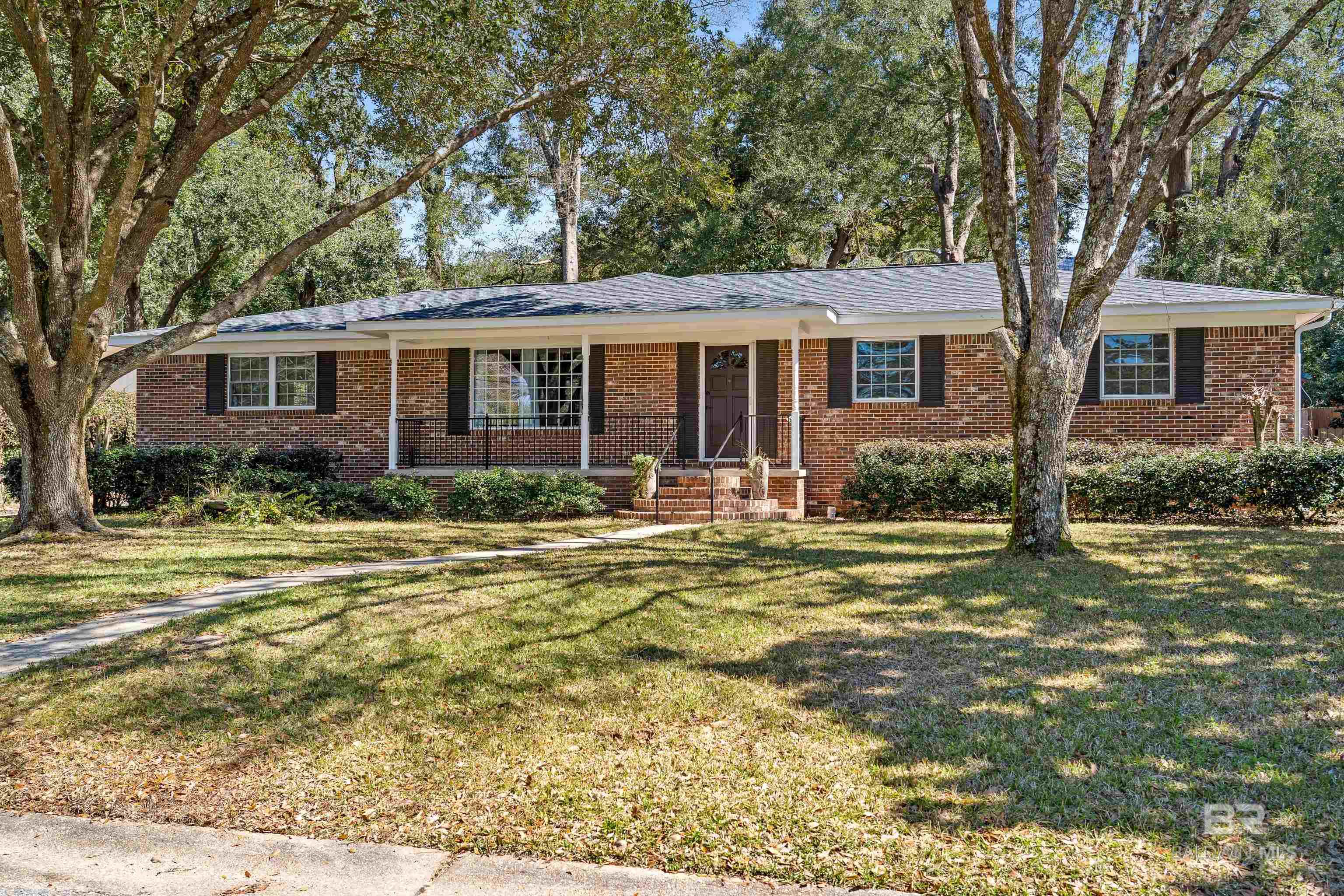 Welcome to this Fairhope ranch style brick home in an ideal location close to town for quick access to shopping, dining, schools and hospital! 3 bedrooms, 2 bathrooms, large bonus room, and open floor plan make for easy living. Oak hardwood floors. The heart of the home is the kitchen which features an island, granite counters, white cabinets, electric range with induction stove top, refrigerator, dishwasher, microwave, an eat-in breakfast area. Living Room is open to the kitchen and offers lots of natural light. Laundry area includes a washer/dryer. Primary bedroom overlooks backyards and has an en suite bathroom. Guest bedrooms share a hall bathroom with tiled shower/bath. Covered front porch. Screened back porch as well as a rear extendable awning for enlarged outdoor living and entertaining. Irrigation system in front and back yard. Fenced backyard offers 3 sheds (20x17 workshop, paint studio, and tools) and is a gardener's delight. Fountain by patio is powered by a solar panel. Fortified roof 2023. New water heater 2025. New smoke detectors. Security lighting. Buyer to verify all information. All information deemed reliable and accurate. Buyer to verify all information during due diligence.