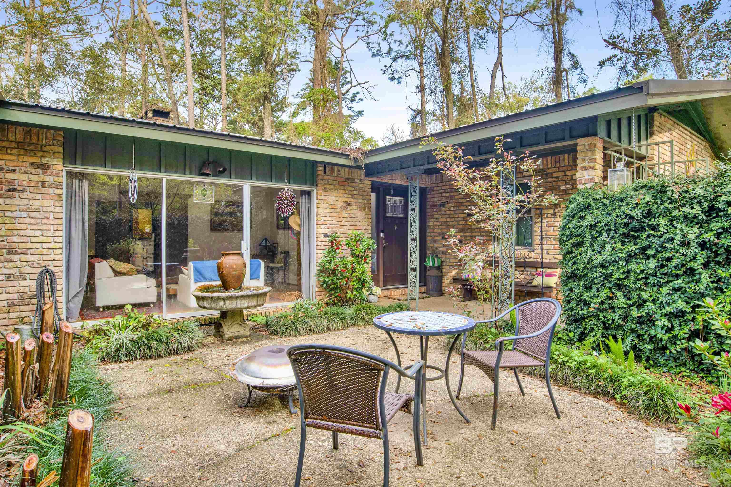 This is a Coming Soon Listing. Rare find in Fairhope. Best of both worlds, two+ acres of natural beauty just a short walk to downtown Fairhope. You can hear the birds sing as well as the chiming of the Fairhope clock from your own backyard. Single story brick home with bronze fortified metal roof in 2021. Nice courtyard at entryway. Beautiful hardwood floors in living & dining room. Nice bright kitchen with pretty painted cabinets, granite countertops, breakfast bar with dedicated breakfast area. Separate family room has wood burning fireplace. Graciously sized laundry room just off the kitchen. Easy access to a large 29'x12' deck . Art studio with electrical services is 16x10 could serve multiple purposes. New Generator in 2023 . Impact windows installed 10 years ago. Home has attached double garage as well as a detached carport. HVAC approx 5 years old. Dining room light fixture, gun safe, outdoor swing & window shutters in art studio do not convey. Buyer to verify all information during due diligence.