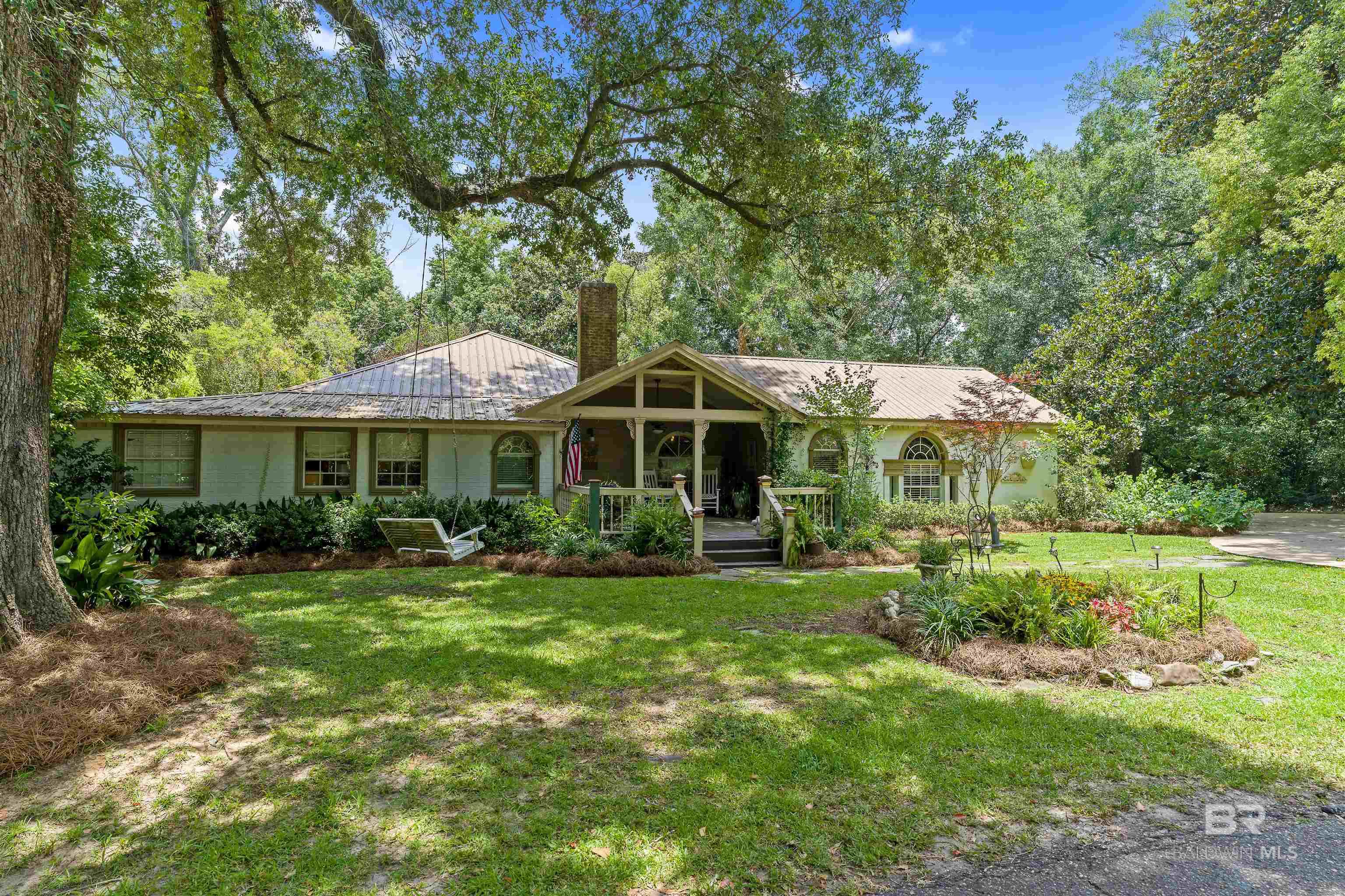 ***NEW PRICE - LET'S MAKE DEAL!*** Step into a masterpiece at 257 Morphy Avenue, a haven in Fairhope's Fruit and Nut District where historic elegance meets contemporary artistry. This 4-bedroom, 3.5-bathroom sanctuary spans 3,315 square feet, offering a canvas for those who cherish both space and style. As you cross the threshold, original wood floors narrate a story of timeless beauty, guiding you through a space adorned with stainless steel appliances and sleek butcher block countertops in the kitchen. The living room's arched entryways and vaulted ceiling create a sense of expansive creativity, while custom trim work throughout the home blends an air of refined craftsmanship. An attached mother-in-law suite provides a private gallery space for your guests, ensuring both comfort and seclusion. Imagine entertaining in the intimate courtyard, with home-crafted cocktails from the wet bar setting the scene for unforgettable evenings. The property is surrounded by mature oak trees, their graceful branches framing your artistic retreat with the essence of southern Alabama charm. One of the home's standout features is the exposed wall in the guest bedroom, a historical mosaic of construction materials sourced from Clay City Tile, a company with deep roots in Fairhope's architectural heritage. The living room's historic fireplace, a mesmerizing centerpiece built in 1850 and imported from Belgium, adds a touch of Old World allure to the space. Just one block from Church St and two blocks from Section St, this residence is a gateway to downtown Fairhope's vibrant cultural tapestry, including the Arts and Crafts Festival, Mardi Gras parades, and the Lighting of the Trees. A leisurely half-mile stroll brings you to the Fairhope Municipal Pier, where the coastal scenery becomes a serene backdrop for your artistic inspiration. Seize the opportunity to own this enchanting Fairhope retreat, where every corner whispers tales of history and the warmth of southern hospitality. Buyer