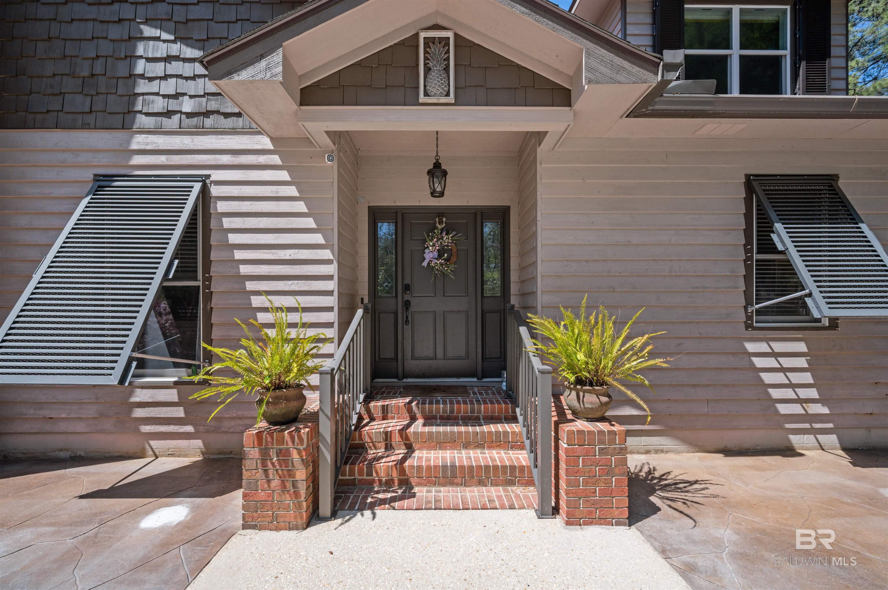 RARE OPPORTUNITY to own 6.4 acre FAMILY COMPOUND on D'Olive creek, located in the heart of Daphne, featuring a main house nearly 3900 sq ft (which includes 900 plus sq. foot studio apartment with private entry) and a 1200 sq ft Morton built home with RV hookup! NO HOA AND the ability to add more structures.  The tranquil secluded grounds you will find abundant fruit trees and a WELL. The main house is 5 bedrooms/4.5 baths and has been updated to include: Whole house Generator, Gas Tankless water heater, new plumbing, & new lighting, all under a Fortified Roof! If 3900 sq ft isn't enough, there is an additional 1200 sq ft of space in the walk-out basement- currently used as storage and a game room and could easily be converted into another apartment! The smaller home on the property is Morton built (2021) and is open concept with a fully equipped kitchen, large walk-in closet, W/D hookup, and single car garage. A full RV connection is at the rear of the home. This unit can be used as a home, office, or rental income! Both homes feature full home surge protection, whole-house carbon filter, city-water and sewage.Want more?  This expansive property also features a pool with gated deck, separate patio area, and garage. Also a 25 x 26 covered carport & 12x30x12 covered RV/boat carport w/30 amp hookup.Whether you are looking for a multi-generational property or an income producing property (with unlimited opportunity for your vision), this property is worth a look! Be close to everything while feeling away from it all!  State of Alabama licensed agents. Call for more info. Property can be subdivided if desired. Can hold more structures/homes. Can be shown easily by appt. Buyer to verify all information during due diligence.