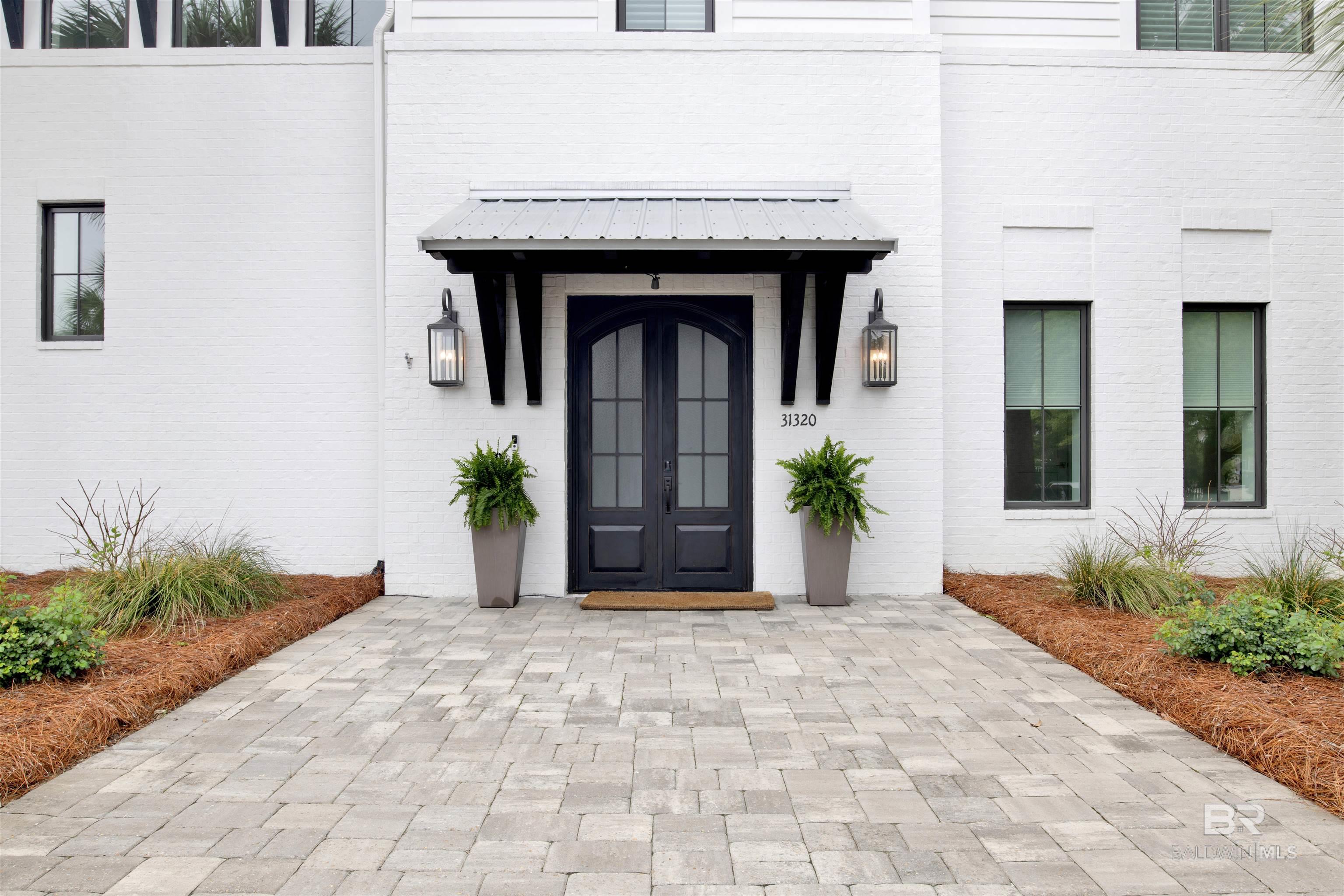 Located on one of the most coveted islands on the Gulf Coast, this modern masterpiece lies on one of the highest elevated lots on Ono Island. This beautiful gold fortified home crafted by McCollough Architecture and J L Loper boasts 100' of direct Old River frontage. Luxury permeates every inch of this home with six generous bedroom suites. The main level of the home overlooks Old River and has a well appointed poolside terrace, magnificent open great room with solid cypress beams and floor-to-ceiling sliding glass doors which seamlessly blend indoor and outdoor living, a spacious dining room and gourmet kitchen outfitted with top-of-the-line finishes and Thermador appliances. The main level also features a powder room, two private and luxurious primary bedroom suites with large closets and access to the poolside terrace and two extra guest bedrooms connected with a Jack and Jill bathroom. Descend the architecturally stunning staircase or take the ELEVATOR to find large foyers. The downstairs area has a spectacular media room with seating for nine, a wine tasting room with large modern wine cooler, two additional bedroom suites and a game room ensuring effortless entertaining, 1282 sf finished garage, solid concrete walls with 12' encasements, and a 22K generator which serves the main level. A remarkable boathouse with 16,000-pound capacity boat lift, jet ski lift for two jet skis; premium flow-through decking and over 4.5 feet water depth completes this extraordinary offering. Peaceful, luxurious and spectacular. Buyer to verify all information during due diligence.