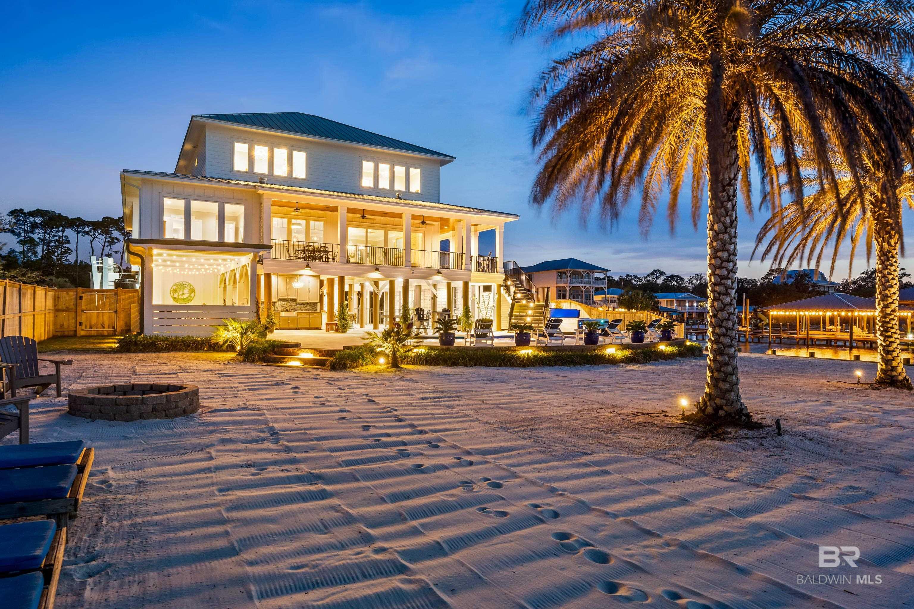 Welcome to your dream waterfront retreat in the highly desirable Bear Point community, this remarkable property captures the essence of coastal living and is designed to provide sweeping views of the intercoastal waters, creating an inviting atmosphere for modern lifestyles in Orange Beach.As you approach the home, you will be captivated by the custom medallion compass driveway that elegantly guides you to the entrance. Step onto the porch adorned with beautiful cypress tongue-and-groove ceilings and enter through the grand solid mahogany doors. Inside, you’ll discover an airy open floor plan featuring soaring 10-foot ceilings, with stunning views from the living room, dining room, and kitchen with a magnificent 14-foot curved island topped with elegant Shadow Storm natural stone.The main level boasts a generous primary suite, complete with a custom walk-in closet that doubles as a safe room. The spa-like primary bathroom offers a luxurious walk-in glass shower with stunning Carrera marble, a relaxing soaking tub.The second living level has four additional generously sized guest rooms and a second laundry center. The main guest room is a luxurious escape with breathtaking waterfront views of your private beach, a spacious closet, and a personal en suite bath featuring double vanities and a glass-tiled walk-in shower and the second and third guest rooms. Plus, a fourth bedroom suite that is perfect for an inspiring workspace or relaxation space.Experience a lifestyle where luxury meets functionality, beauty, and the relaxed essence of coastal charm with an amazing outdoor space that includes, an cabana and lounge area with a big screen tv, a beautifully designed in-ground pool, a fire pit area, jacuzzi spa, and your own private sandy beach steps away from the custom boathouse with both a boat lift and double wave runner lift. This is truly an exceptional home. Call for a private tour today. Buyer to verify all information during due diligence.