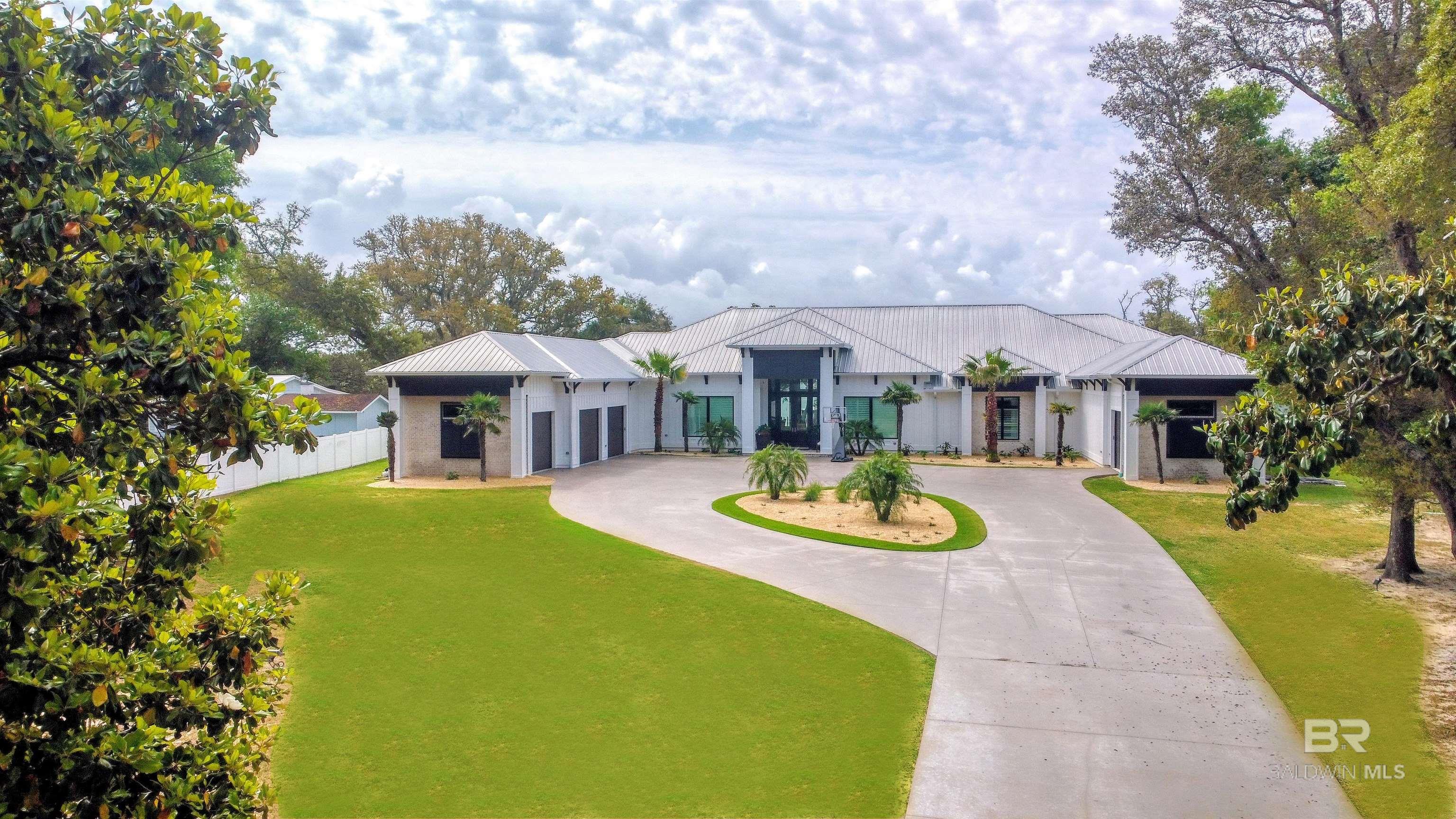 Where Coastal Elegance Meets Timeless Luxury.   This 7BR/8BA + 2 half-bath waterfront estate is the epitome of coastal sophistication. Set on elevated ground with 190' of private beach and a 2021 dock upgrade that includes flow-through decking and has deep-water access, this smart home features a chef’s kitchen with Thermador appliances, his-and-hers offices, game room, 140 inch screen theater, safe room, and custom security system. Enjoy a 9 foot deep saltwater pool, 10x10 spa, and full outdoor kitchen, all designed for flawless indoor-outdoor living. This is more than a home- it's a lifestyle. Every detail has been meticulously curated to offer a seamless blend of luxury, comfort and refinement, allowing you to fully relax and enjoy the essence of paradise. Buyer to verify all information during due diligence.