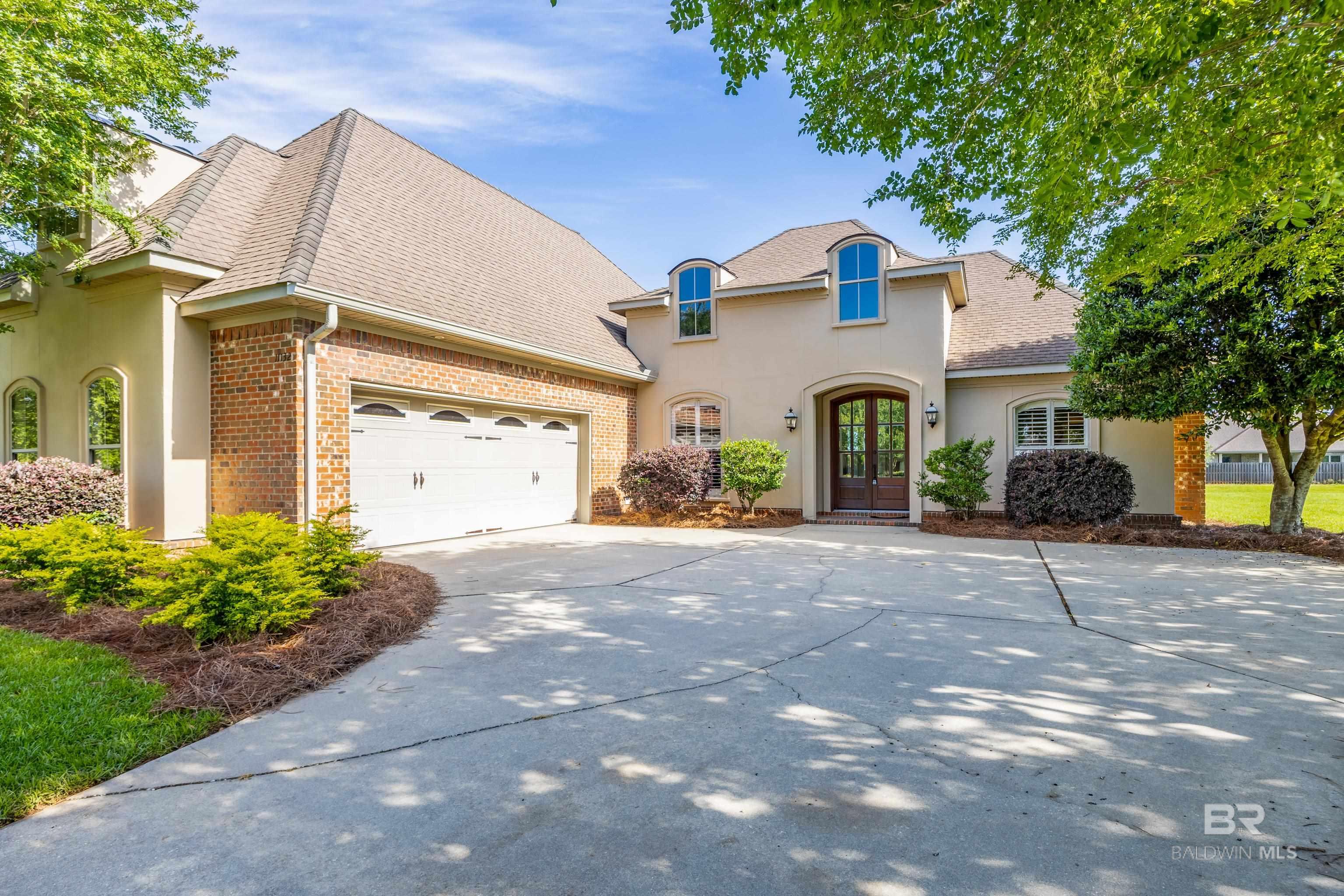 Step into elegance and comfort at 11132 Elysian Circle—an exceptional custom-built home located in the sought-after Austin Park community. Perfectly positioned on an oversized, meticulously landscaped lot, this property combines timeless architecture with everyday functionality and access to some of Baldwin County’s premier amenities.Designed for both daily living and entertaining, the open-concept layout showcases rich hardwood flooring, crown molding, and custom millwork throughout. The gourmet kitchen is the true heart of the home, featuring granite countertops, a large furniture-style island, stainless steel appliances, and custom cabinetry that offers abundant storage and warmth.The main living area is flooded with natural light and anchored by a fireplace, with seamless transitions to the formal dining room and breakfast nook. The spacious primary suite features a tray ceiling, expansive walk-in closet, and spa-inspired bathroom with dual vanities, a soaking tub, walk-in shower, and private water closet.Three additional guest bedrooms are thoughtfully arranged in a split-bedroom layout for privacy, with one of them located upstairs as a full guest suite—complete with its own bathroom and dormer-style window niche; think multigenerational living, a teen retreat, or a home office. Enjoy outdoor living year-round from the covered back patio overlooking the expansive backyard, framed in manicured landscaping. The oversized side-entry garage offers added convenience, storage, and curb appeal. Located just minutes from the Eastern Shore Centre, restaurants, and the I-10 connector, this home offers both tranquility and convenience—an ideal choice for buyers seeking space, quality construction, and a strong community atmosphere.Spend sunny afternoons at the community's resort-style pool, get active on the tennis and basketball courts. Families will appreciate the shaded playground, while the scenic community pond—with its swing, benches, and fishing. Buyer to verif Bu