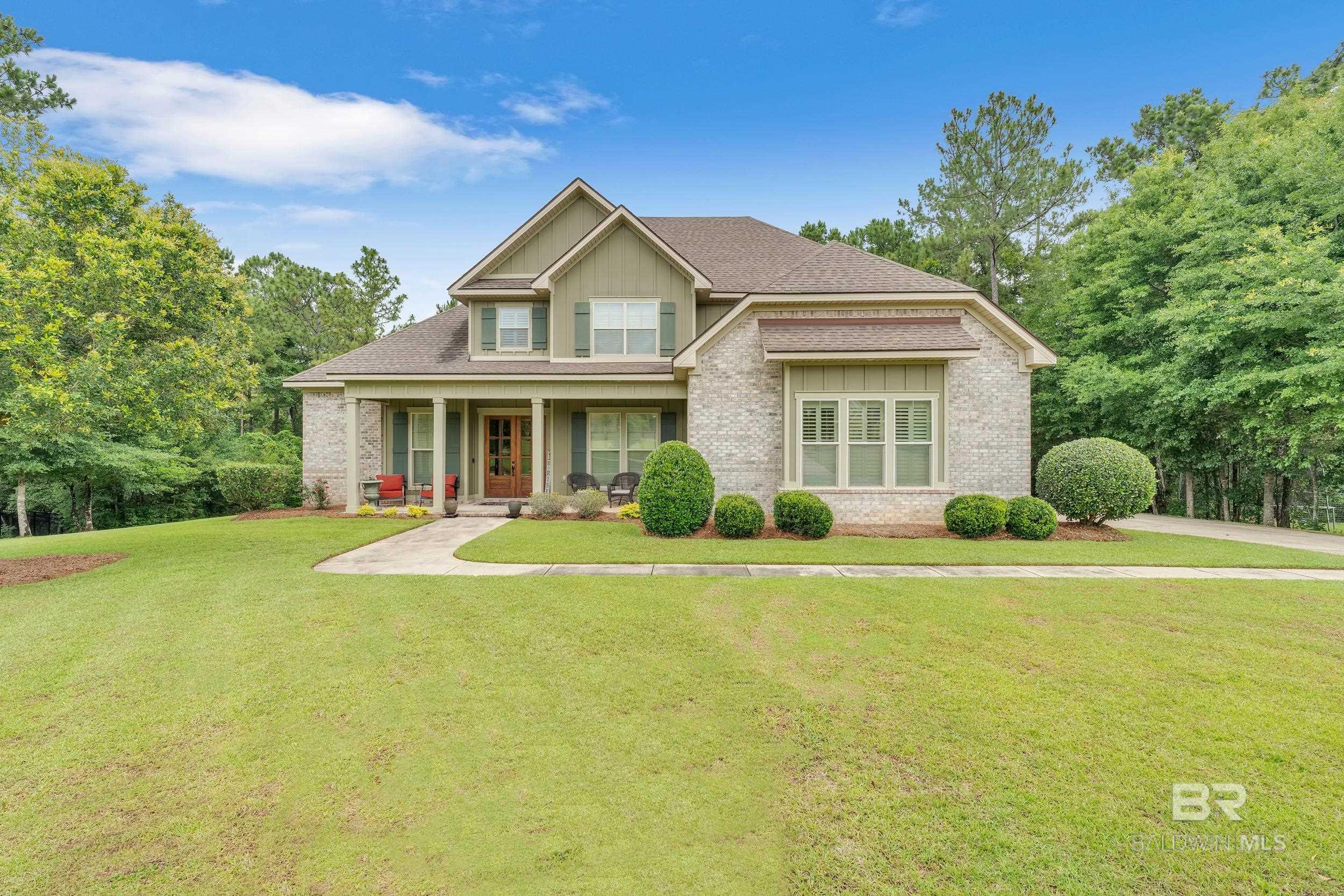 Step into elegance with this immaculate 5-bedroom, 3-bath masterpiece boasting a cozy keeping room with fire place and timeless architectural charm. From the moment you arrive, the curb appeal stuns— mahogany double-door entry, a covered porch, soaring ceilings, and gleaming hardwood floors greet you with warmth and charm.  Inside, the formal dining room wows with elegant crown molding, and picturesque views of the front porch. Custom designed by Truland Homes, this open-concept layout flows effortlessly into a light-filled great room perfect for entertaining or relaxing in style.  The chef’s kitchen is a dream come true: Bosch appliances, sparkling granite countertops, an oversized island with seating for four, plus a working island as well, a premium gas cooktop, pantry, stylish lighting, and 18” tile underfoot. Whether you're hosting brunch or preparing a family dinner, this space delivers both beauty and function.  Retreat to your serene main-level primary suite complete with tray ceilings and a spa-worthy ensuite: granite-topped double vanities, jetted soaking tub, tiled shower, and an expansive 17’ x 9’ walk-in closet. Also on the first floor, a laundry room designed for convenience. Plantation shutters throughout! Upstairs discover a spacious landing, three generously-sized bedrooms oversized walk-in closets and full bath with double vanity. The exterior is as low-maintenance as it is beautiful, with a striking blend of brick and Hardie siding and thoughtful landscaping. The screened back porch offers a tranquil view of your tree-shaded backyard, complete with a patio.  Plenty of space to add your dream pool or outdoor kitchen! The double garage features after market tile flooring, driveway has extra parking for additional vehicles. Located just off County Road 13 in Daphne,The Estates of Tiawasee offers estate-sized wooded lots, rolling hills, scenic walking paths and peaceful surroundings. Buyer to verify all information during due diligence.