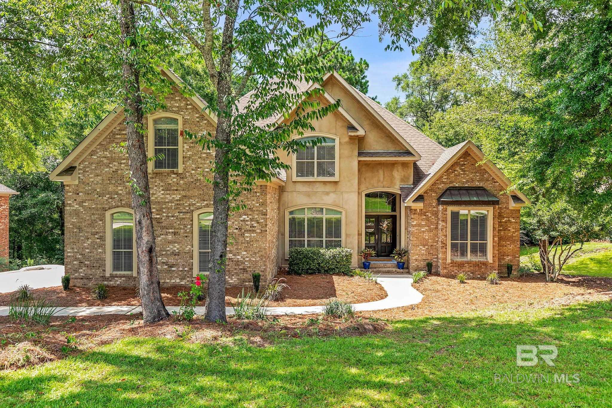 Welcome to 30230 D’Olive Ridge, a beautifully updated home in the highly sought-after TimberCreek community zoned for Spanish Fort schools. This property offers an ideal blend of luxury, space, and function.It has solid white oak hardwood floors in pristine condition, with carpet in the guest bedrooms/upstairs. Ceiling fans with remotes are installed throughout. The formal dining room features a large picture window and elegant wainscoting, while a separate office provides a private work space. The spacious family room includes a gas-burning fireplace and opens to a large screened-in back porch overlooking a private, wooded lot.The kitchen features granite countertops, custom wood cabinetry, a tile backsplash, stainless steel appliances, a gas cooktop, built-in microwave, double ovens, a center island, a walk-in pantry, and a large breakfast room.The primary suite is generously sized and offers direct access to the screened porch. The en suite bathroom includes marble countertops, double vanities, a jetted tub, a separate shower, and a spacious walk-in closet. Bedrooms two and three are oversized and located on the opposite side of the home for privacy. Bedroom three includes an en suite full bath, while bedroom two has access to a full bath just off the hallway. Upstairs, you’ll find a large bonus/living room, a fourth bedroom, a full bath, and a custom walk-in closet, along with floored walk-out attic space for additional storage. The home also includes a large laundry room with a drop zone and a side-entry two-car garage. Includes an alarm system and an irrigation system. Just off the screened porch, a 24x14 patio provides access to two additional spaces: a 16x8 workshop with a built-in workbench, and a 14x12 finished, heated/ cooled room. Previously used as a professional recording studio, now a home gym includes mirrors, a small stage, and a vocal booth.Do not miss out on this home and resort-style amenities in the TimberCreek community! Buyer to verify all inf