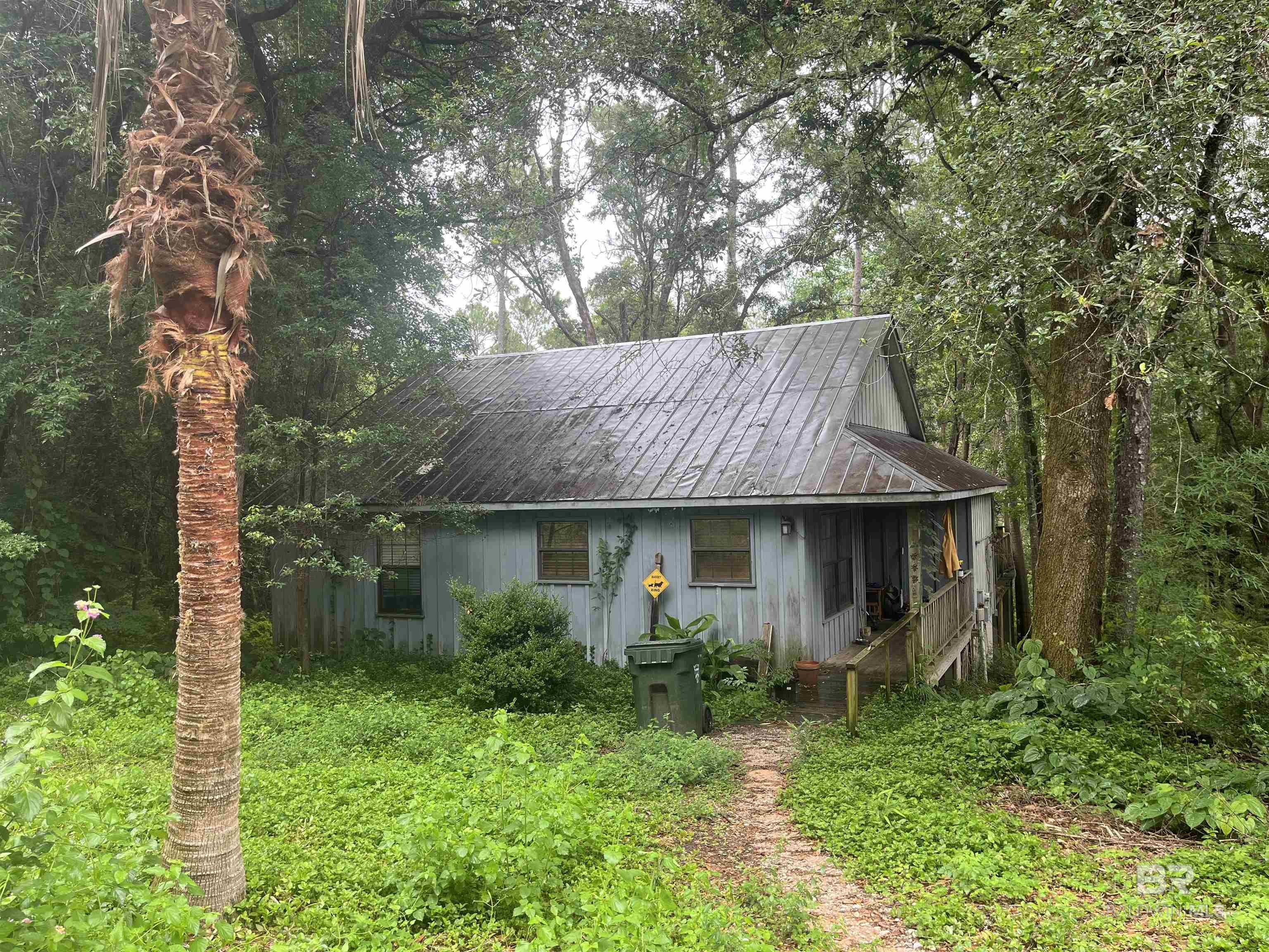 Handyman Special! Calling all investors! 2 bedrooms 1 bath cottage in need of repairs. Open concept with vaulted ceilings in the kitchen and living area with non working fireplace. Beautiful half an acre wooded lot on a narrow part of Fish River. Fun to kayak and canoe. Maybe 10 minutes from downtown Fairhope. In the Fairhope school district. Home being sold "as is where is" Everything is in working order as far as the seller knows but the seller does not warrant that everything works. Enter the home or the deck at your own risk. Home has a septic tank and well water. Home has never flooded. Home is being rented. With an accepted offer, seller will give the renters a 60 day notice to move out. Buyer to verify all information during due diligence.