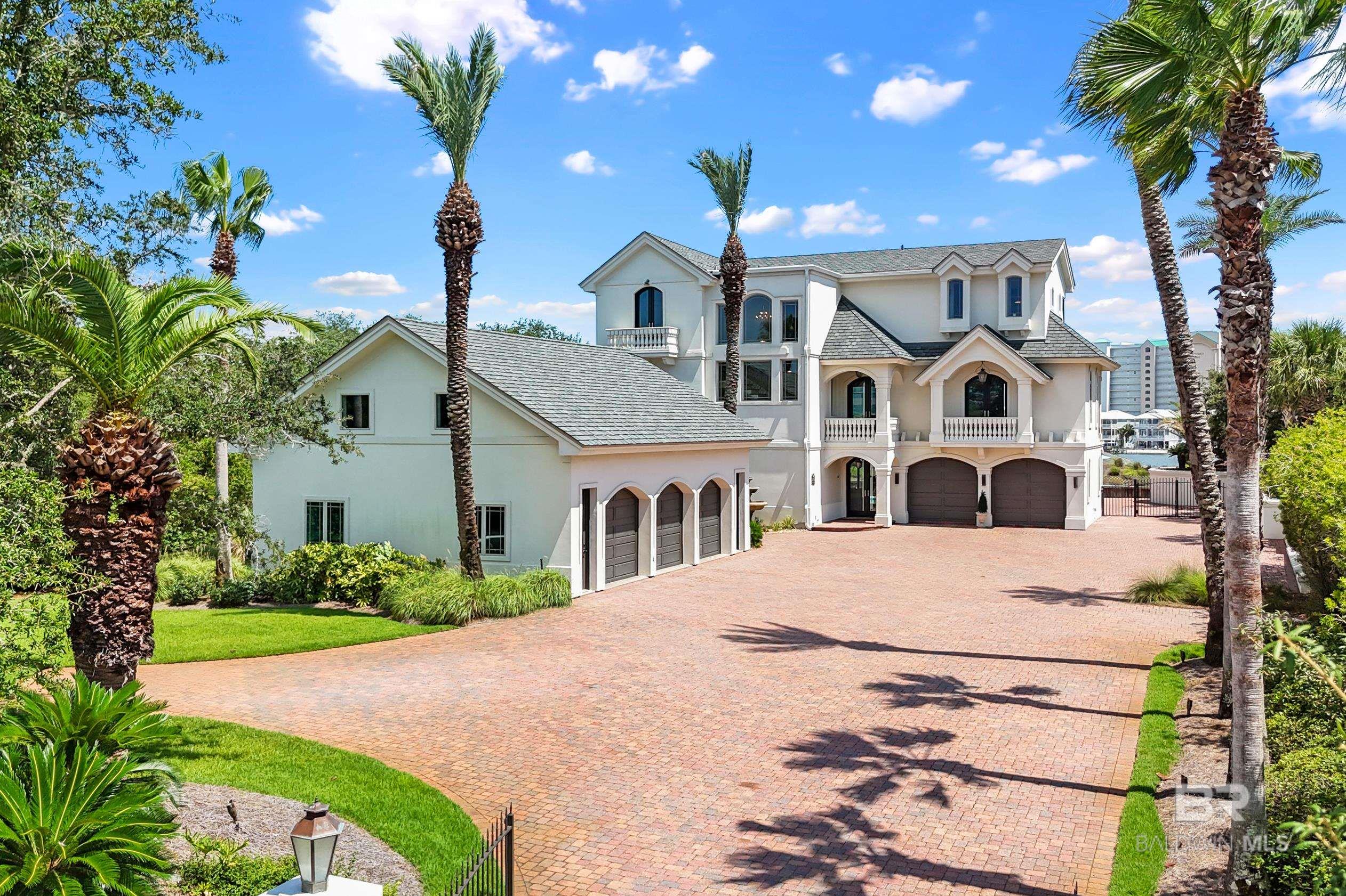 Welcome to this exquisite Mediterranean style waterfront retreat on Ono Island, offering 100 feet of prime waterfront on Old River, less than a mile from the Ono bridge! Designed for luxury and built to last, this ICF concrete construction masterpiece features high end stainless appliances, a gas fireplace, impact windows and doors, tankless water heater, private elevator, TWO laundry rooms, a fantastic rec room complete with a bar and a billiard table and a card table, a butler’s pantry & wet bar, beautiful furnishings by Cindy Meador Interiors, an outdoor kitchen with gas grill, beautiful pool, boat house with 2 boat lifts, and 100’ of private white sandy beach on Old River. The huge primary suite features a large sitting area, large custom closet, two water closets and a bidet, a soaking tub, and gorgeous water views. In addition to the 6,100 square feet of living space, there is a detached heated and cooled 3-CAR GARAGE that has plenty of room for all of your toys, custom cabinets, a full bathroom, and a large loft area that would be great for a man cave or media room. There is over 2,300 sq ft of covered porches and patios, and a tiki hut that are all ideal for sunset cocktails, weekend barbecues, or morning coffee. Enjoy incredible views of Old River, the Gulf, and Bayou St John. With it’s gated driveway and mature landscaping, this property offers so much privacy. The roof on the home and boat house were replaced in 2020/2021. The exterior was painted and resealed, and new impact exterior doors were installed in 2022. Home sits high and dry in X Zone! Home conveys furnished. Ono Island is a premier residential island community with a guarded entrance that provides privacy and security for its residents. Community amenities include a fitness center, indoor & outdoor pool, tennis & pickleball courts, playground, boat launch, and 24-hour security! Buyer to verify all information during due diligence. Virtual tour coming soon!