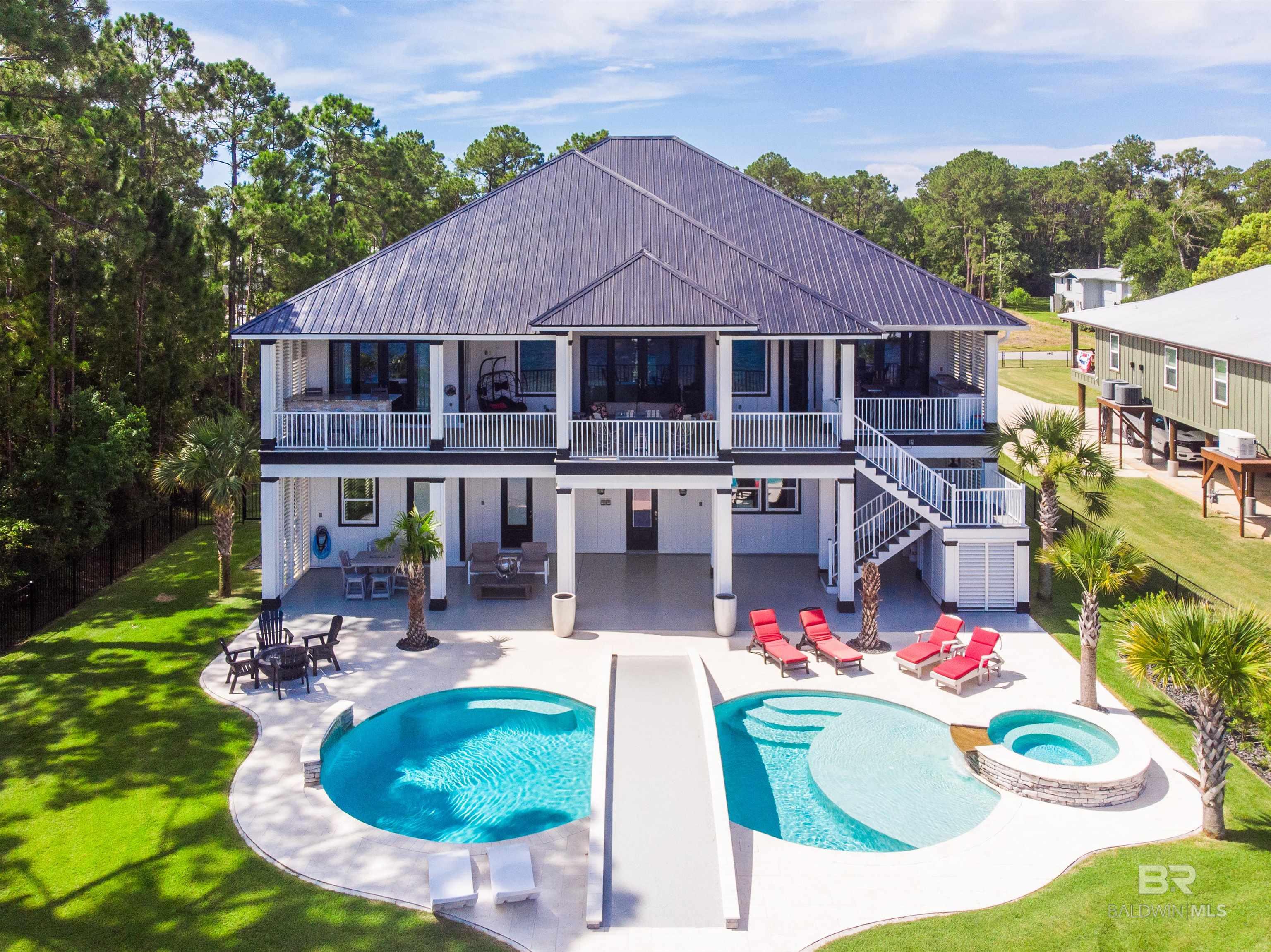 Welcome to your coastal dream retreat on Bay La Launch, where 78' of private beach and over 4000 square feet of beautifully designed space await! Wake to breathtaking sunrises and end each day with magical sunsets from your own backyard oasis. The open concept main level features vaulted reclaimed wood ceilings, an electric fireplace, and a stylish wet bar! The chef's kitchen is a masterpiece with custom maple cabinets, gas cooktop , and oversized sink. Three serene bedrooms offer en-suite bathrooms with a dream closet in the primary suite, plus another flex room, walk-in pantry, and large laundry room with lots of storage space! The lower level of this home has been transformed to include a bunkroom, a wine room and a captain's quarters with an additional full bath. Beautiful epoxied flooring has been added to provide a durability with a creative flare! Entertain on the expansive deck with outdoor kitchen and plenty of seating then dive into your custom gunite pool with an overwater bridge. The private dock features flow thru/TREX decking and two boat lifts (30K & 16K), Killerdock fishing station, refrigerator, ice maker and a lounge area. This home was built to Gold-Fortified standards, includes an elevator, additional ice maker, commercial refrigerator and a doggie door on lower level. Professionally landscaped with irrigation and lighting to ensure tranquility anytime of day or night. No HOA (optional property owners boat launch is two lots over)! Make this home your pure waterfront bliss! Buyer to verify all information. Buyer to verify all information during due diligence.