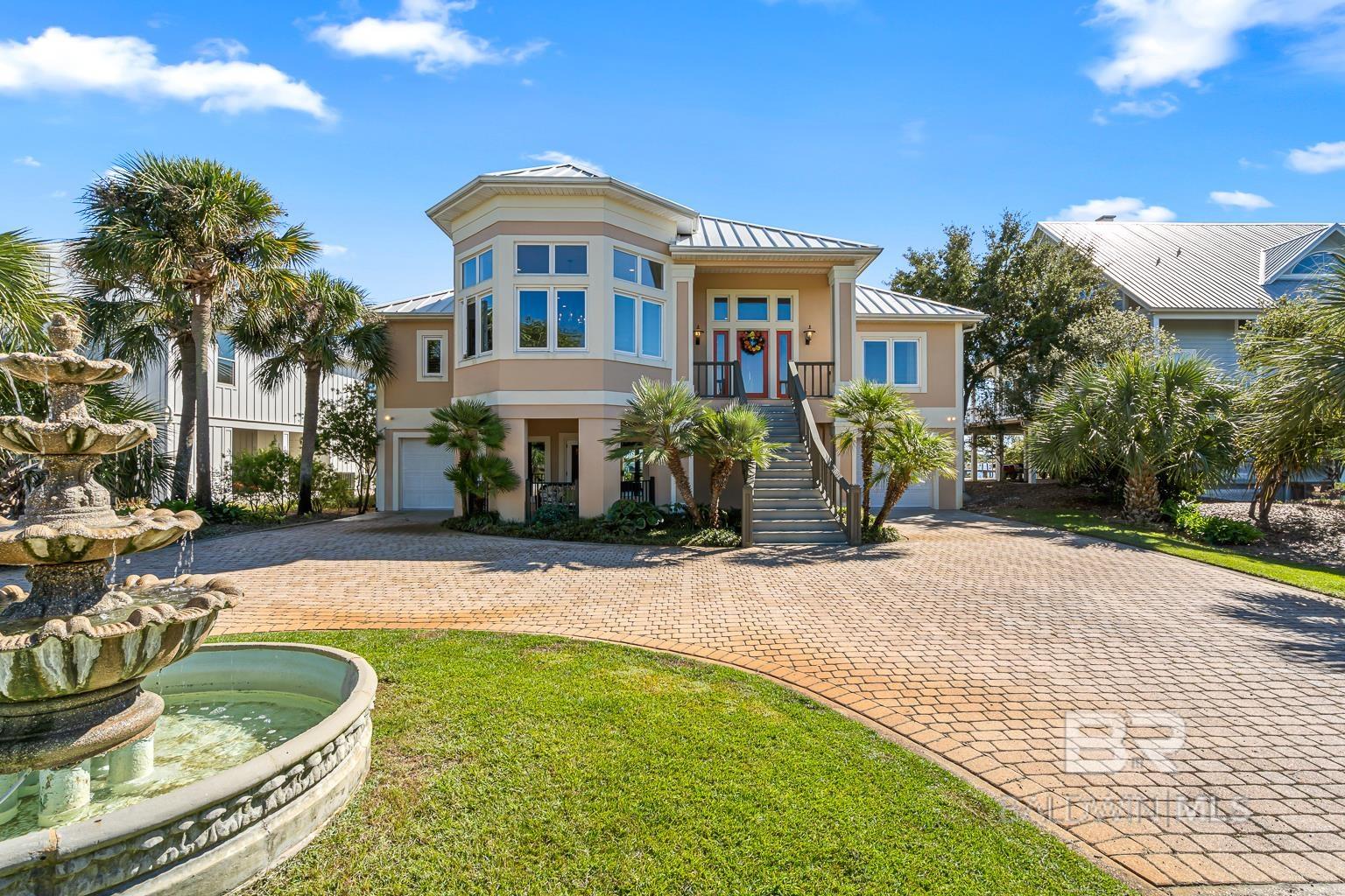 Unobstructed water views, comfortable luxury, and a layout designed for everyday coastal living coming together seamlessly in this well-appointed waterfront home. Located on Ono Island, a private gated community within Orange Beach, the property overlooks Old River the protected shoreline of Perdido Key State Park.As soon as you step inside, walls of windows pull your attention straight to the water, while natural light enhances the open layout. Home has two new HVAC systems and New appliances in 2024. Tall ceilings with crown molding elevate the living area, centered by the wood-burning fireplace and custom built-ins. The kitchen, dining, and living spaces flow easily and create a great space for entertaining or relaxing. The primary suite offers private deck access and a peaceful retreat with natural views. Two additional bedrooms are located upstairs, while the lower level includes a guest bedroom and full bath alongside a spacious bonus area for flexible use! Outdoors, enjoy deep-water access, private boathouse with ThruFlow deckings, a 12,000lb lift, and a large outdoor, gunite, swimming pool. New Impact Rated 165 mph windows 2021, all new soffits 2021 and the hot tub is included! Property also includes a heated and cooled workshop. Make this exclusive, water-front home, yours today! Buyer to verify all information during due diligence.