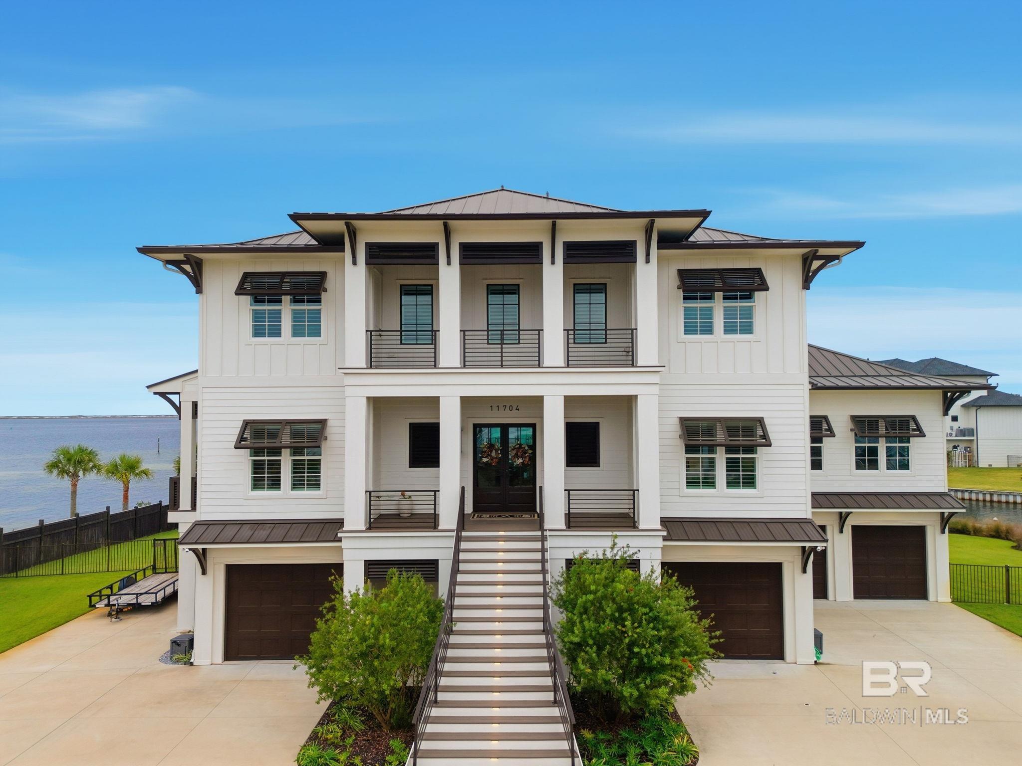 Experience luxury coastal living at its finest in this breathtaking 5-bedroom, 4-bath estate perfectly positioned on a ½-acre cul-de-sac lot with 217 feet of pristine waterfront on the Intracoastal Waterway and a private boat basin. Enjoy panoramic views of the Intracoastal and the Gulf, where gorgeous sunrises and stunning sunsets fill the sky each day—and watch the Blue Angels fly from the comfort of your own backyard.A boater’s paradise, this property offers direct access to the Intracoastal Waterway and is in close proximity to the Pass, providing effortless access to the Gulf of America or fishing, cruising, and coastal adventures.Inside, the home showcases white oak hardwood floors throughout, beautiful moldings, luxury marble and tile bathrooms, and a gourmet kitchen adorned with quartz countertops and backsplash, black stainless designer appliances, a Wolf built-in coffee system, and a butler’s pantry featuring custom cabinetry and walnut counters.The Bar & Game Room exudes a stylish speakeasy vibe, featuring a gas fireplace, walnut bar, beverage refrigerator, Scotsman ice maker, and beverage dispenser—a perfect gathering place for friends and family.Step outdoors to your private resort-style retreat with a gunite heated pool and spa, surrounded by marble decking, and an outdoor kitchen equipped with a Blaze gas grill, Large Green Egg, beverage fridge, prep sink, and a full outdoor bathroom for added convenience.Additional highlights include a whole-house gas generator, an elevator servicing all three floors, and en-suite bedrooms finished with quartz, marble, and designer tile.Celebrated for its exceptional design and craftsmanship, this home has been featured in multiple luxury coastal magazines—a true testament to its architectural distinction and timeless beauty.This extraordinary waterfront residence seamlessly blends modern sophistication, comfort, and the ultimate coastal lifestyle. This is an equitable interest listing where seller is selling only an