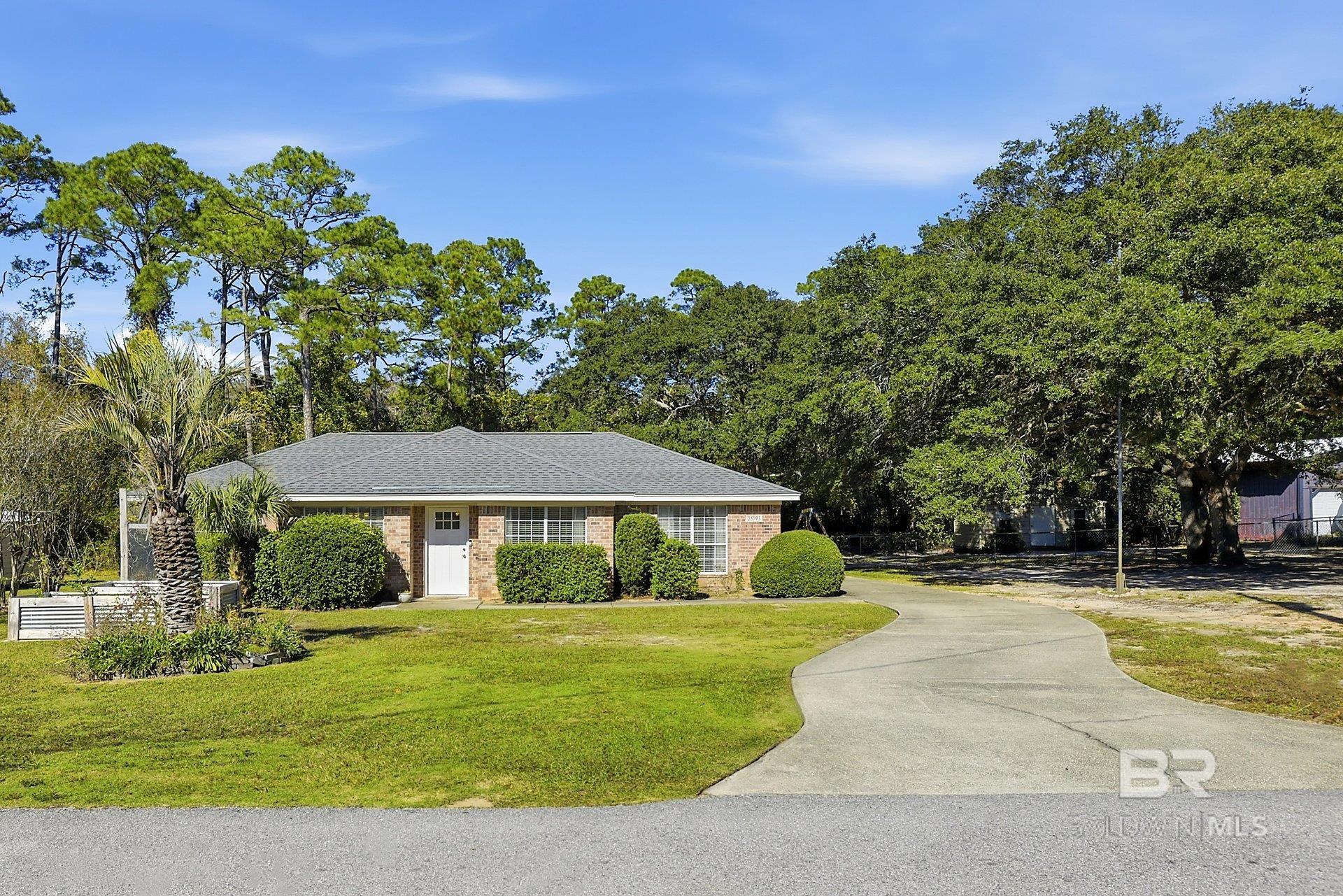 Looking for a LARGE lot in Orange Beach?  This property features 2 lots totaling 150' x 144' and they are in Zone X!  No flood insurance required! The massive live oaks offer beauty and shade. This great brick home is a split floorplan, three bedroom / two bath.  As you enter the house you are can enjoy the sunny sitting room that is shared by the dining area.  Lots of light and a great place to welcome guests.  French doors take you to the kitchen and living area.  A beautiful custom wooden frame brings the two rooms together.  The kitchen has new cabinets, beautiful granite, a tiled backsplash, a large walk-in pantry and stainless/white appliances. There's a large bar for casual dining for four. The house has LVP throughout and smooth ceilings.  The primary bedroom is large, has plenty of natural light and a walk-in closet.  The primary bath offers a walk-in shower, double vanity with frameless lighted mirrors and shiplap.  The second and third bedrooms are spacious have nice closets.  The second bath has a frameless lighted mirror and a tub/shower combination.  The laundry room is off the kitchen and also exits to the 2 car garage. The roof was replaced in 2021.  The house offers a tankless, electric hot water heater that was installed in 2023.  Outside, you can enjoy the screen porch or the open deck.  There's 2 storage buildings on site and the back yard is fenced.  If you want space and don't want an HOA, make sure you see this property conveniently located near shopping, restaurants and just minutes to the beach. Buyer to verify all information during due diligence.