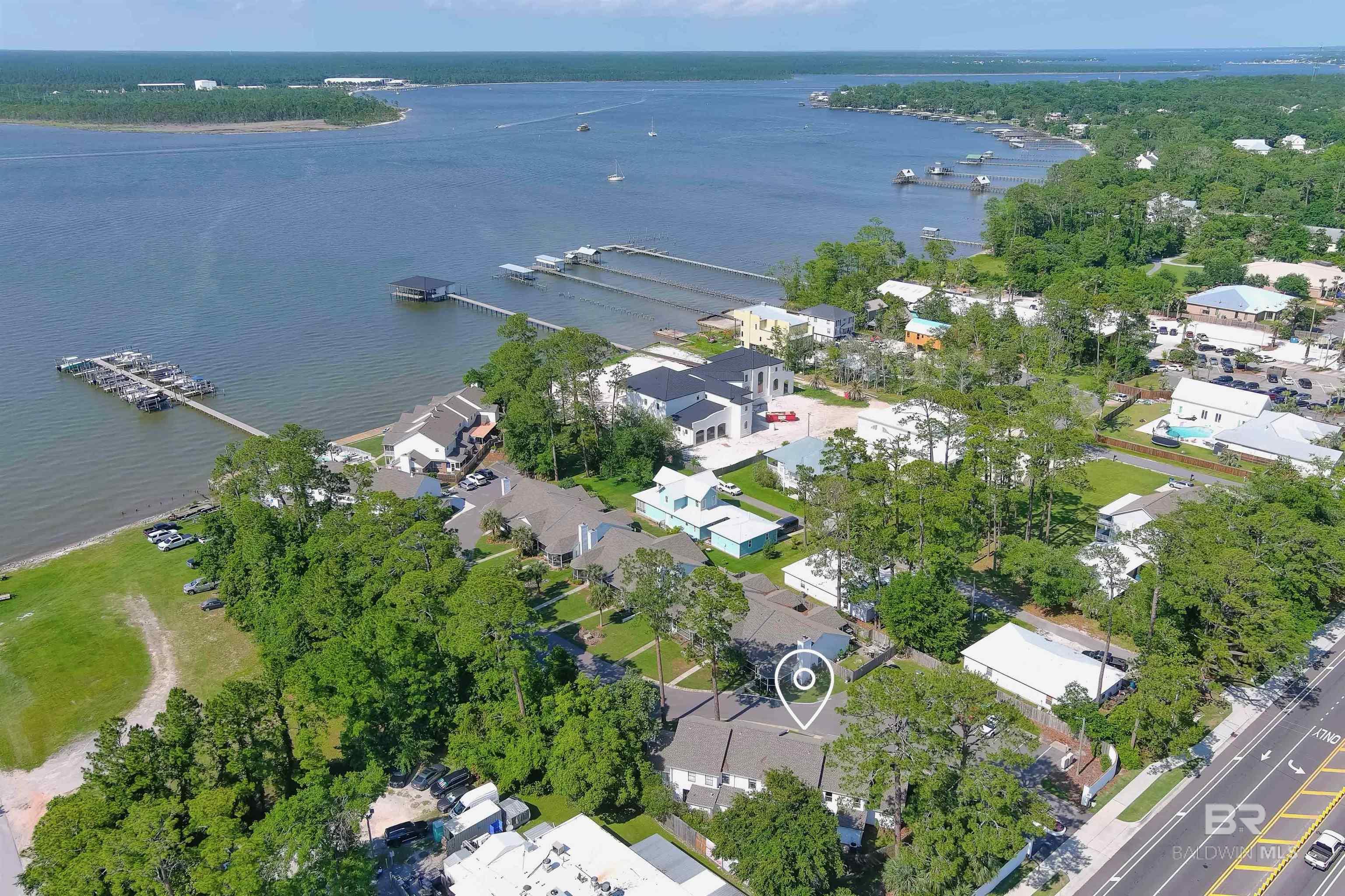 Charming 2BD/1.5BA Townhome with Deeded Boat Slip & Lift on Wolf Bay – Prime Orange Beach Location! Don’t miss this opportunity to own a piece of paradise with this beautifully maintained townhome in the Magnolia Key community (Strong HOA). This unit includes a deeded boat slip with a lift on Wolf Bay, making it a dream for boaters and water lovers. The main level offers a welcoming and functional layout featuring a spacious living area, half bath, kitchen, dining space, and a large utility/laundry room. From the kitchen and utility room, step out onto your private fenced patio, which also opens to a lush, landscaped courtyard and common area great for relaxing or entertaining. Upstairs, you’ll find two bedrooms, the primary bedroom includes a private balcony with beautiful views of Wolf Bay, offering the perfect spot to enjoy your morning coffee or sunset breezes. Additional features include the bayside community pool with water views, fishing dock, and 2 assigned parking spaces. The AC unit was replaced this year. Conveniently located just 2 miles to Cotton Bayou Public Beach access, 3 miles to The Wharf for shopping, dining, and concerts. Close to grocery stores, restaurants, and marinas. This unit is ideal as a primary residence, vacation home, or investment property. This peaceful community has a 30-day rental minimum. Schedule your showing today, this one won’t last long! Buyer to verify all information during due diligence.