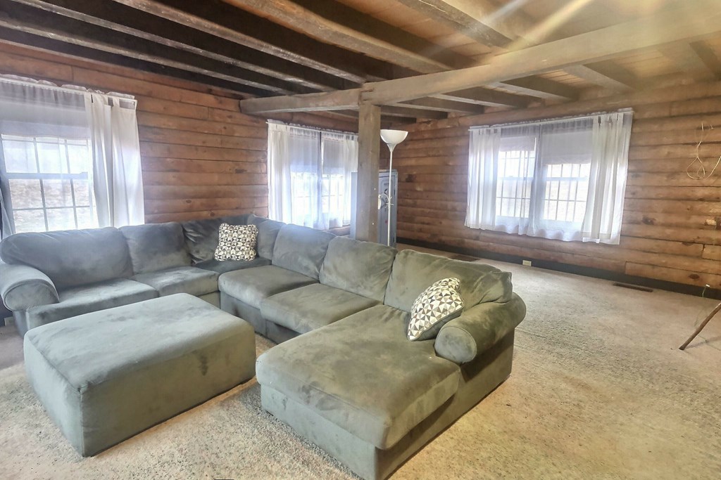 Living room is spacious with several windows and a wood burning fireplace.