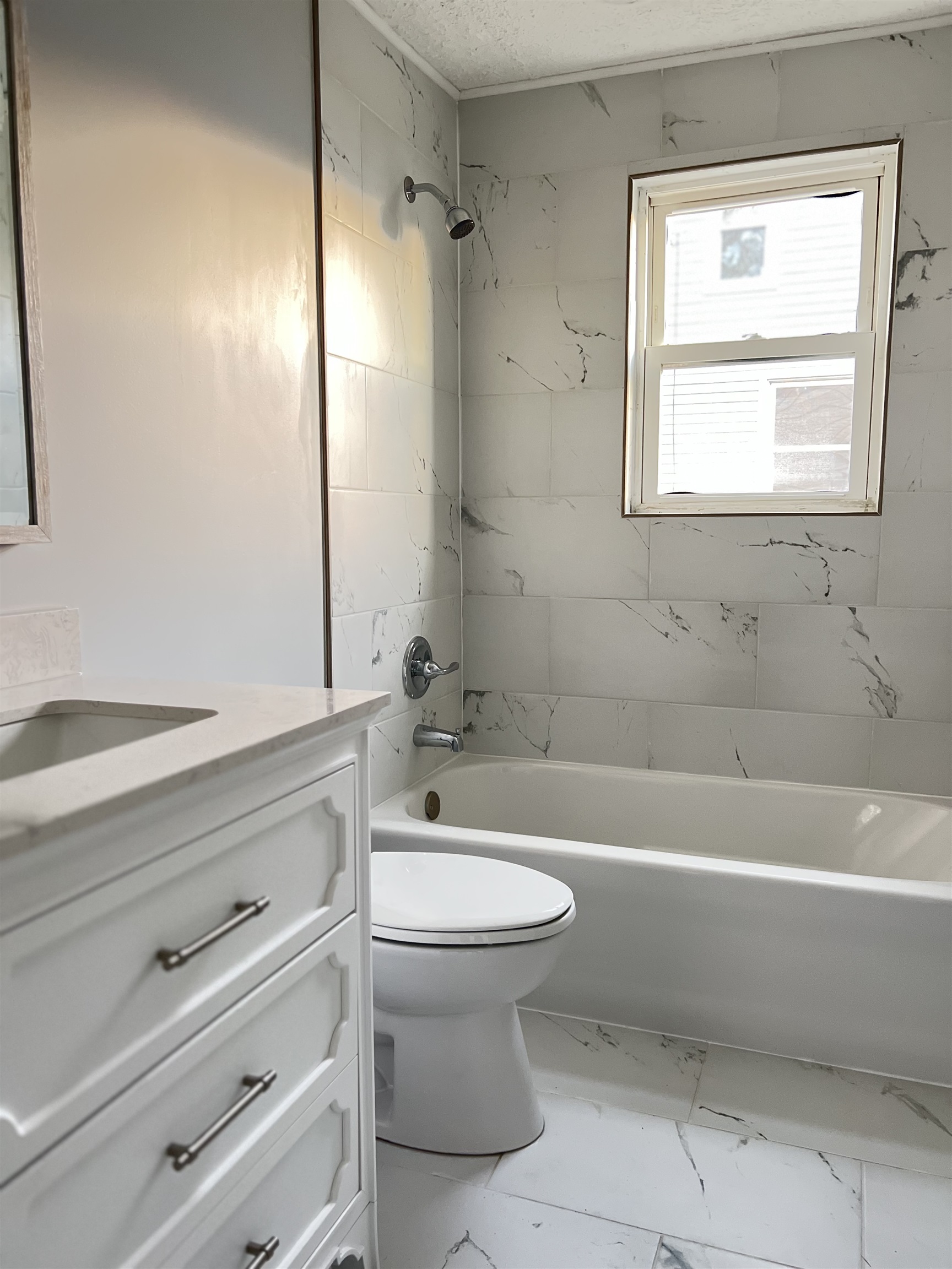 New vanity, ceramic tile flooring and tub surround.