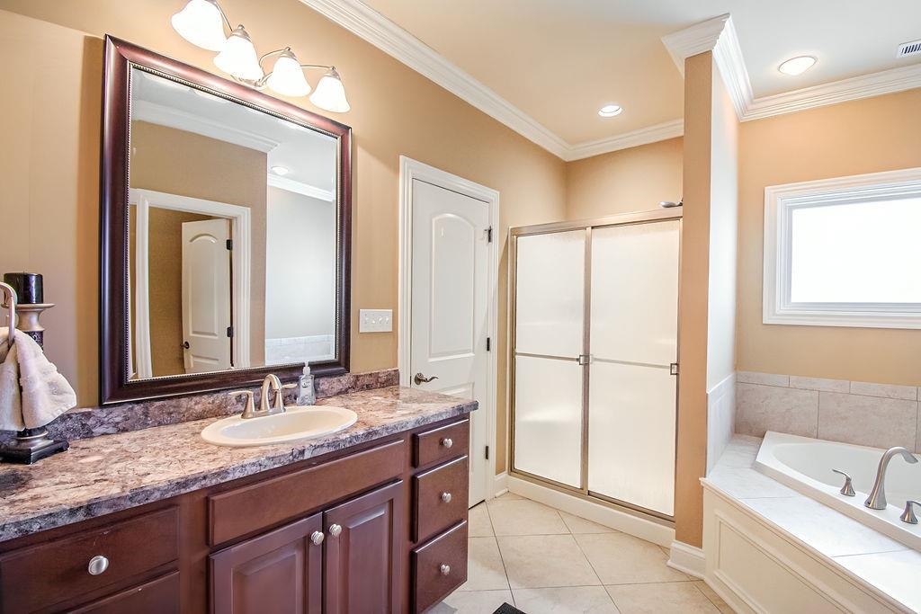 Luxurious primary bath has a whirlpool tub, separate shower, vanity, private bath and walk in closet