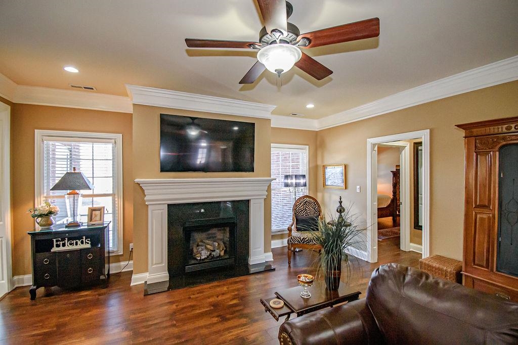 Spacious great room features hardwood flooring, gorgeous fireplace, and elaborate crown moulding!