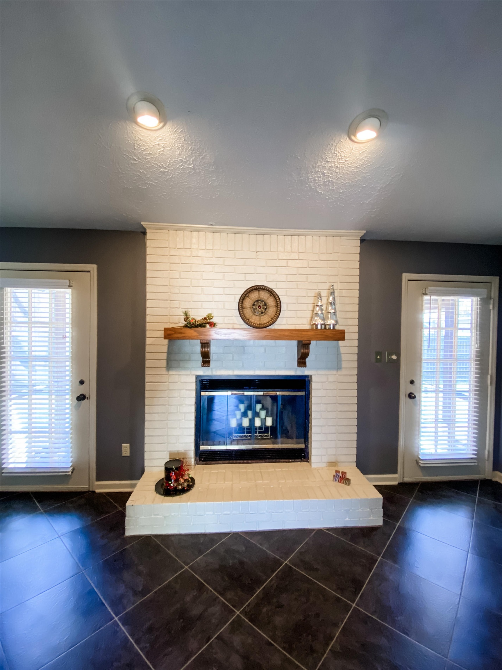 On both sides of the fireplace are doors leading out to the private, screened-in back porch.