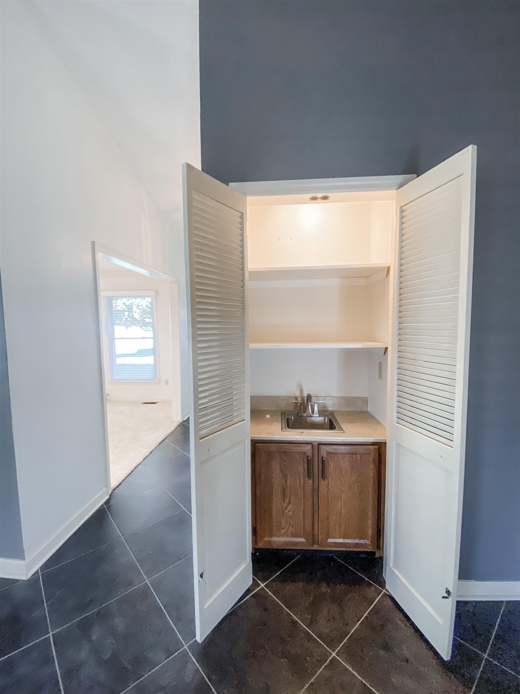 Convenient wet bar located in back living room across from fireplace.