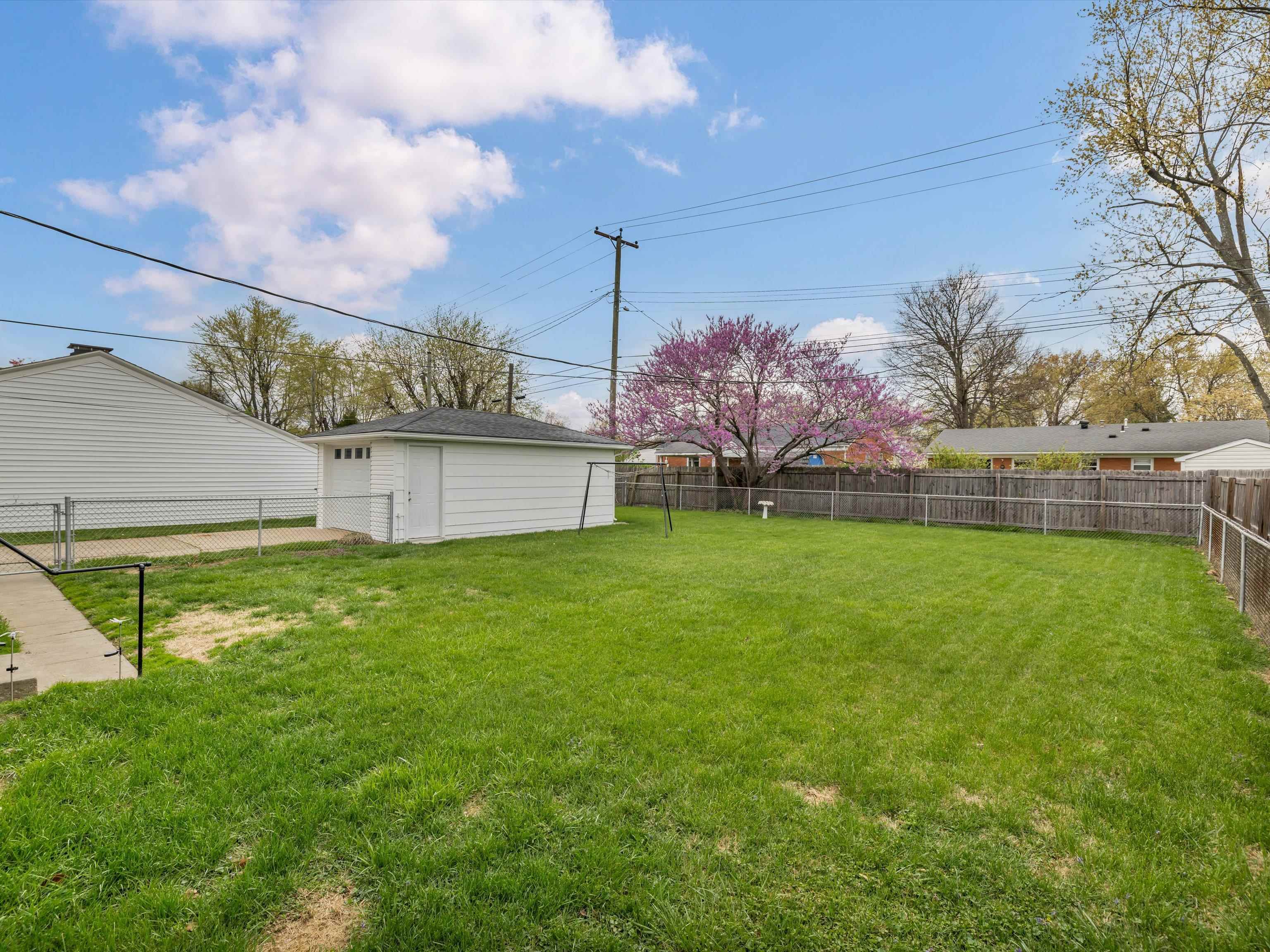 Fenced in Backyard with side view of Garage
