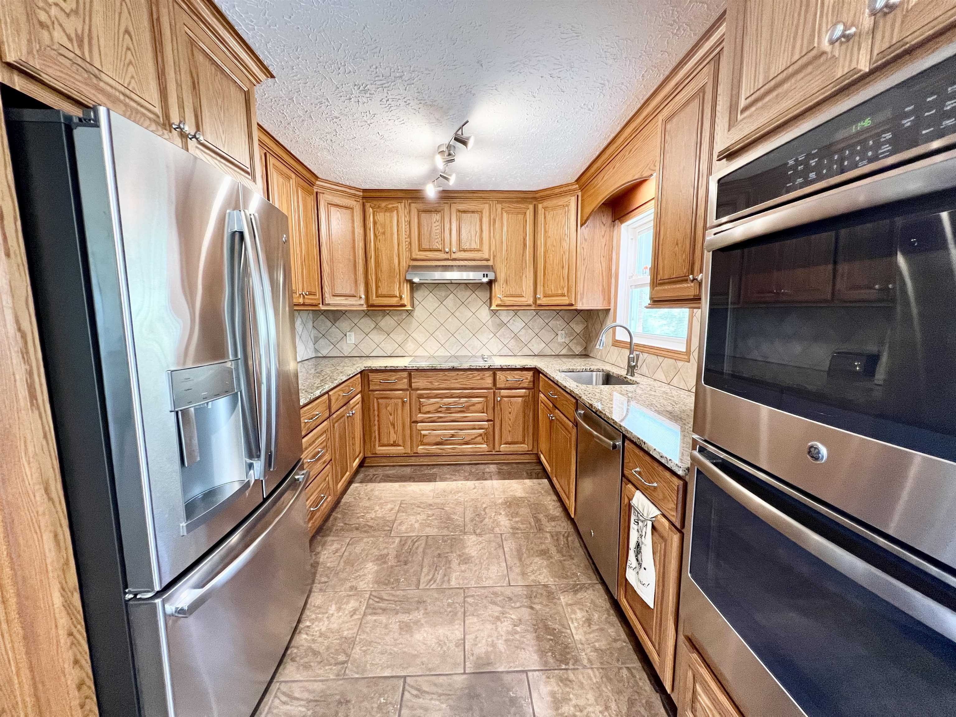 Solid wood cabinets, stainless steel appliances and tile backsplash