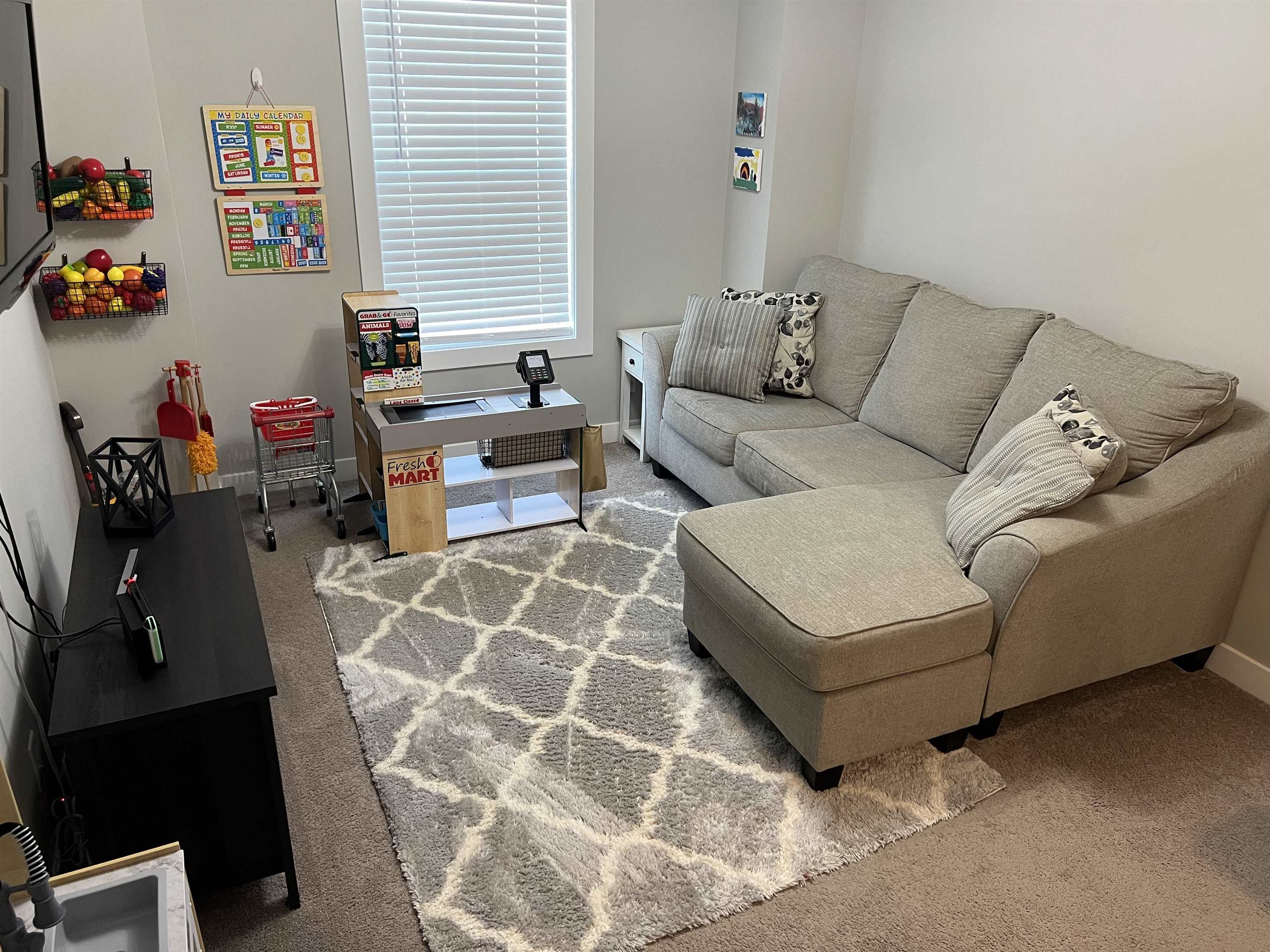 The sitting room at the top of the stairs also serves as a playroom for the kids