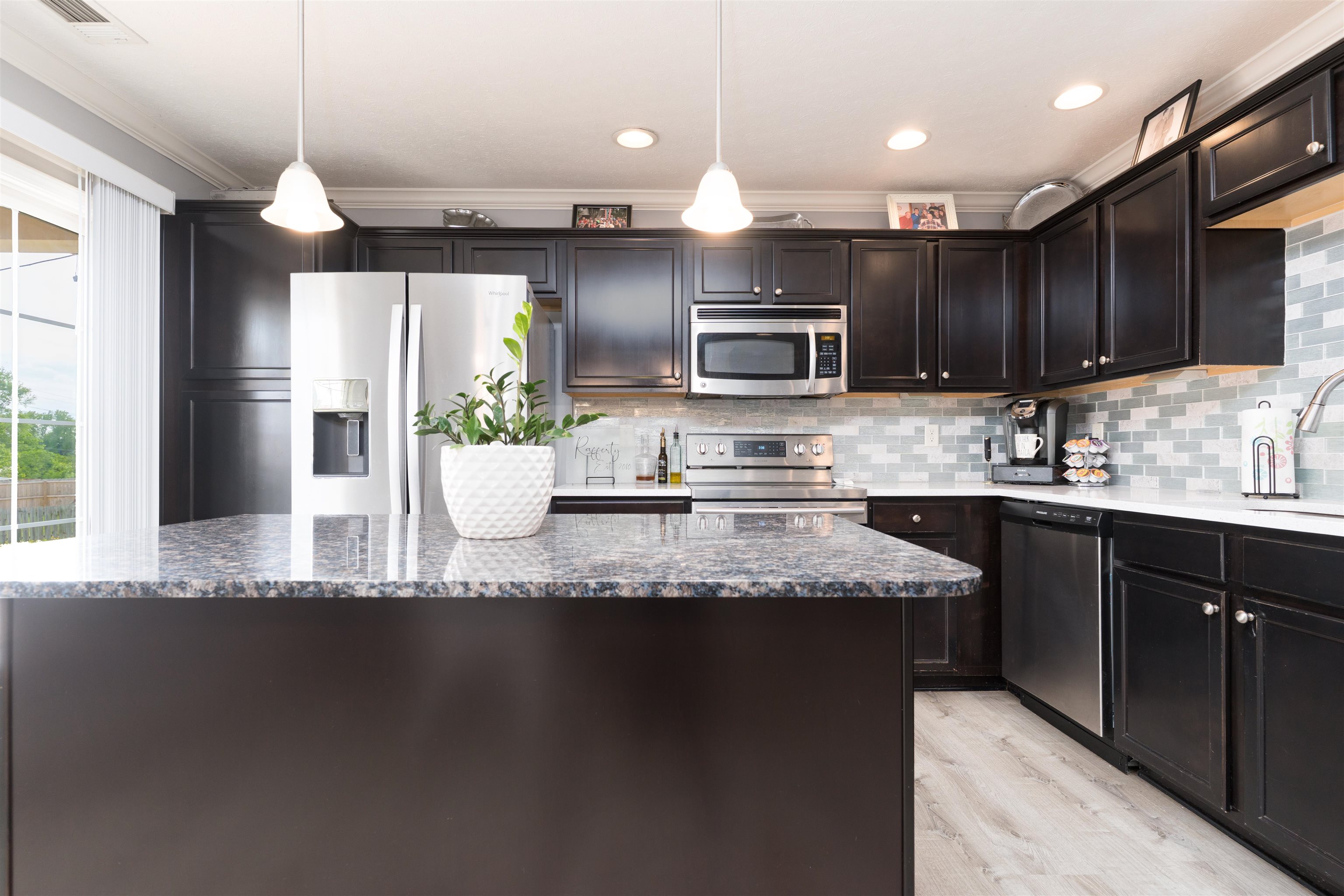 This beautiful kitchen boasts an island in the center, as well as an exit to the backyard.