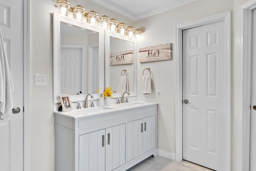 Remodeled primary bathroom features double vanity, soaking tub and ceramic shower