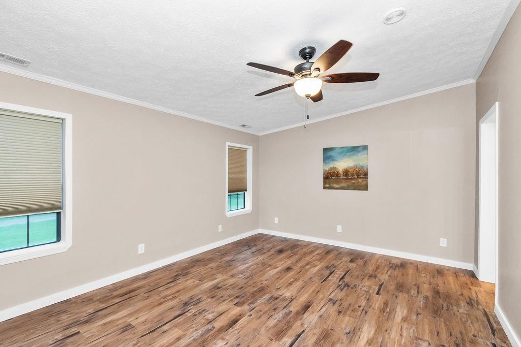 Generous-sized primary bedroom features new flooring, paint and remodeled bathroom.