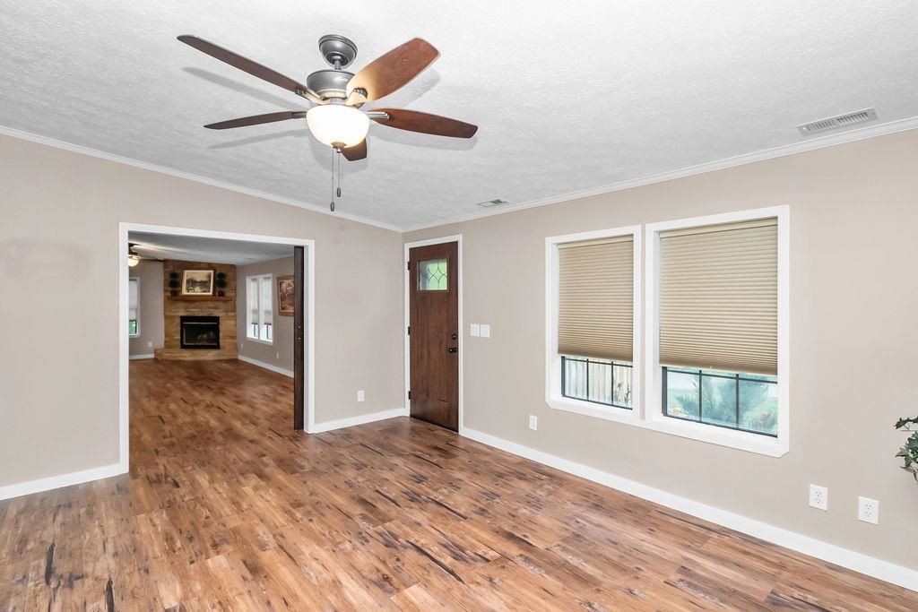 Spacious living room features new flooring, paint, woodwork and ceiling fan!