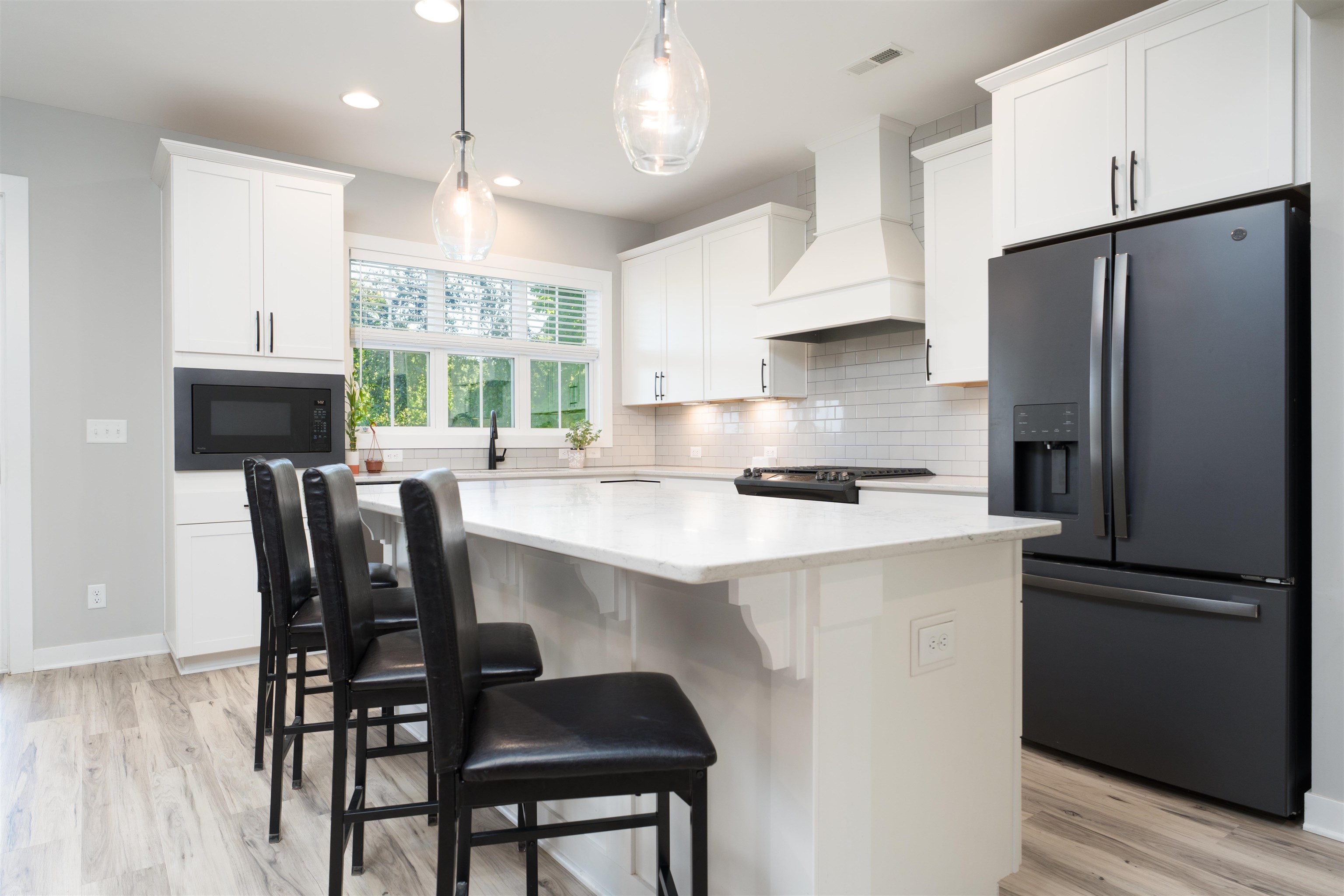 Quartz countertops, extra cabinetry, tile backsplash and slate appliances