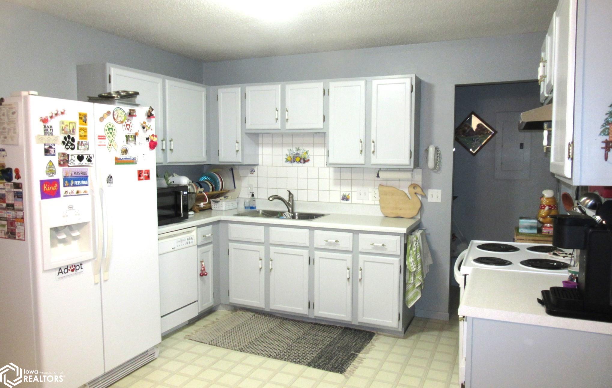White kitchen with ample storage. Appliances to stay with property.  Kitchen open to the Dining Area.
