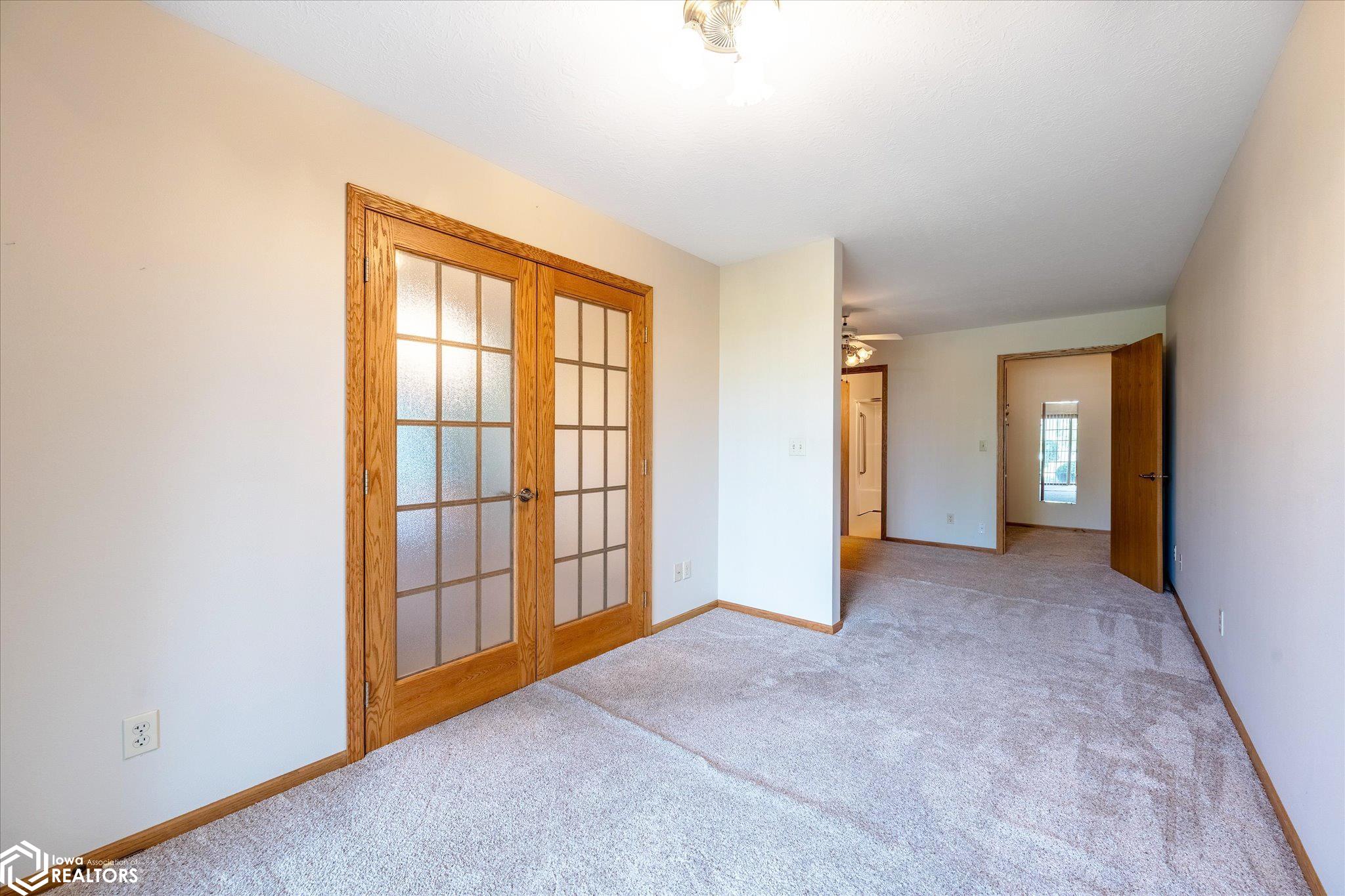 View from the primary bedroom looking W.  The French doors lead to the eat-in kitchen.