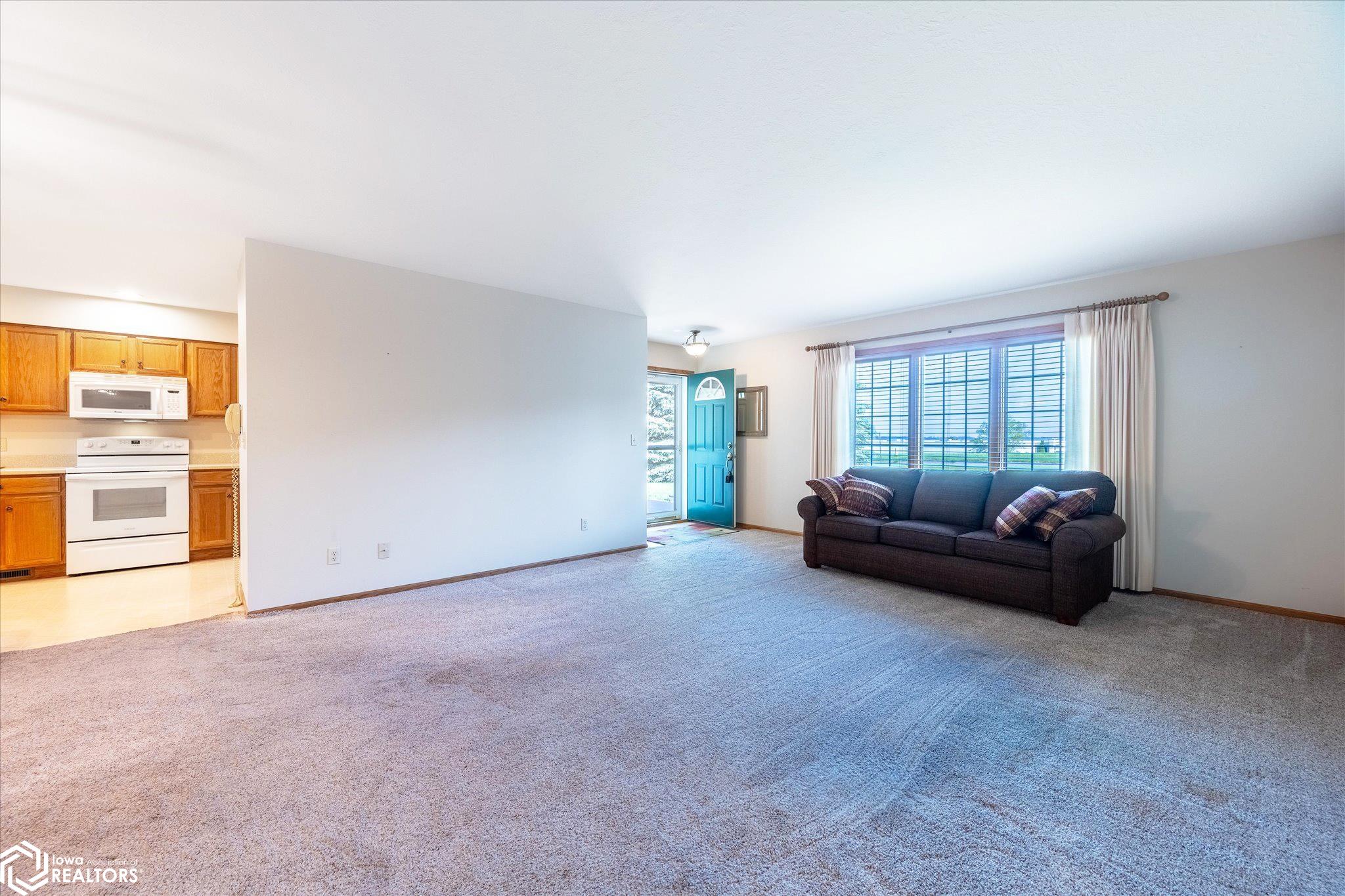 View of the spacious living room looking SE towards the front entrance door.